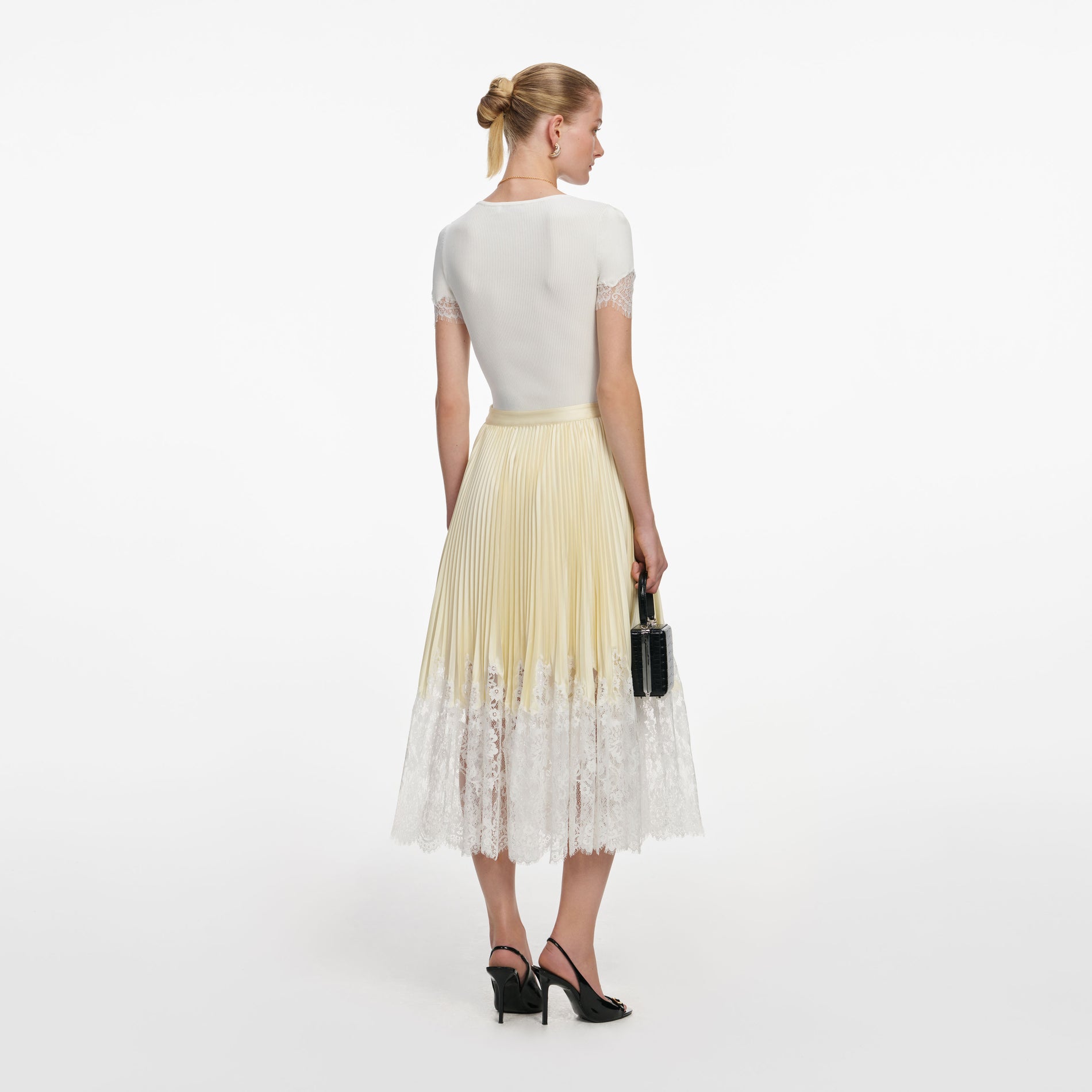 Back view of a woman wearing the Yellow Satin Lace Midi Skirt