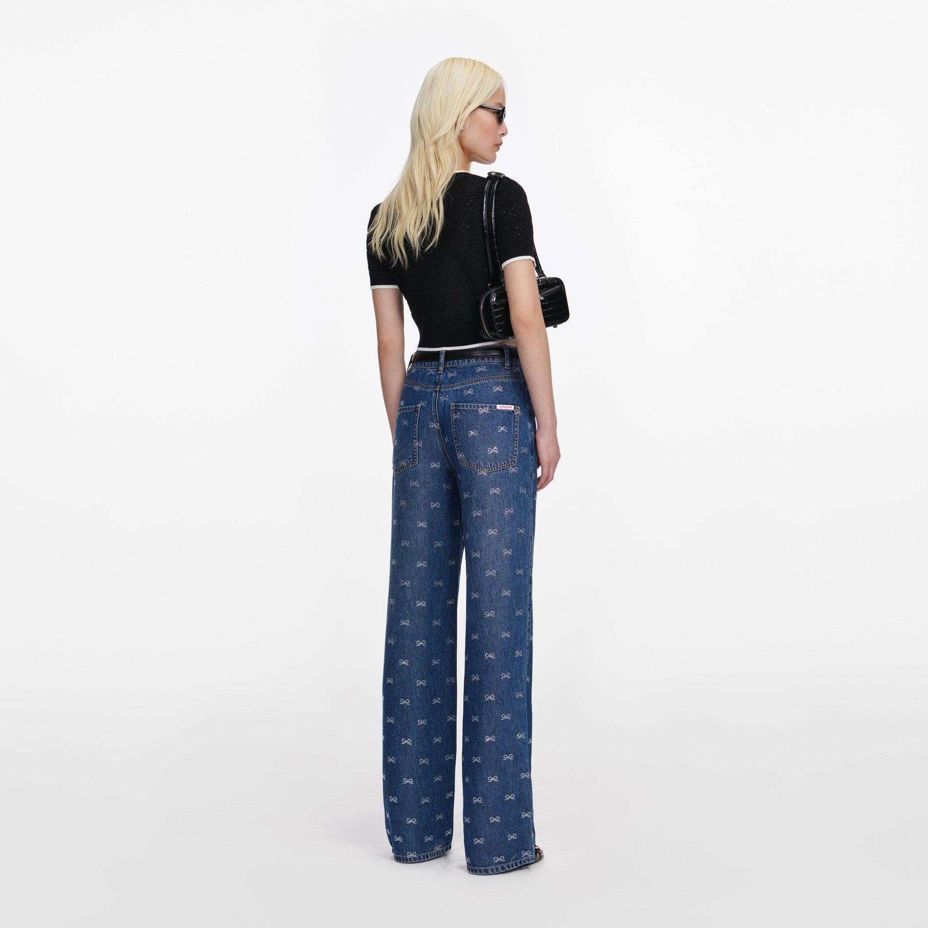 Back view of a woman wearing the Black Pointelle Knit Top