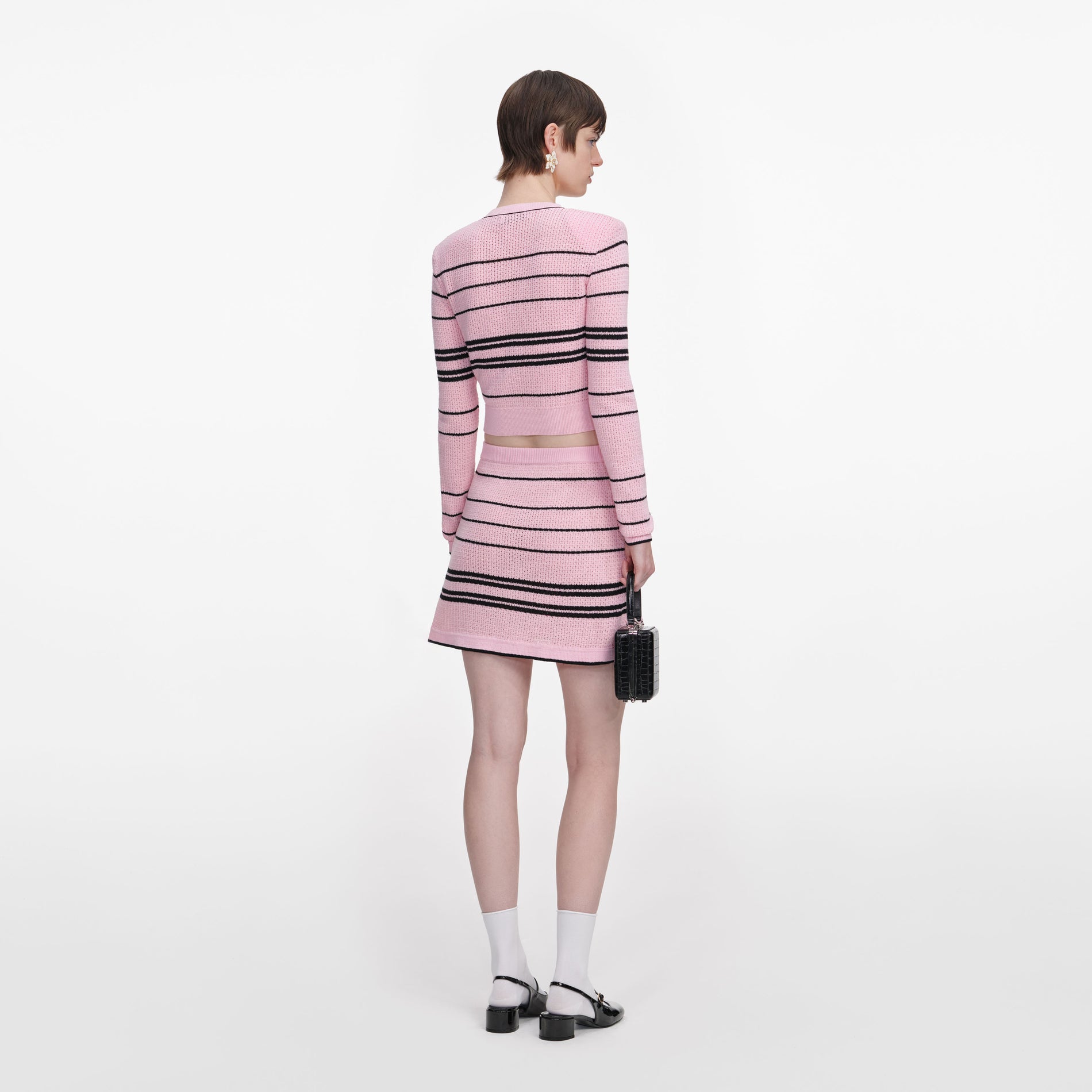Back view of a woman wearing the Pink Stripe Knit Mini Skirt