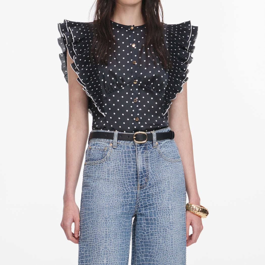 A close up of a woman wearing the Black Polka Dot Frill Top