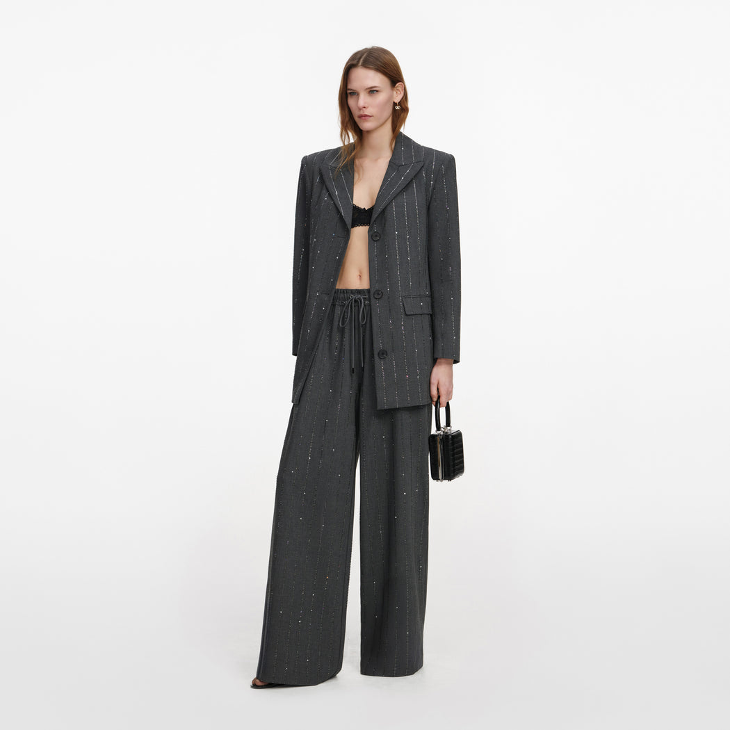 Side view of a woman wearing the Grey Rhinestone Pinstripe Trousers