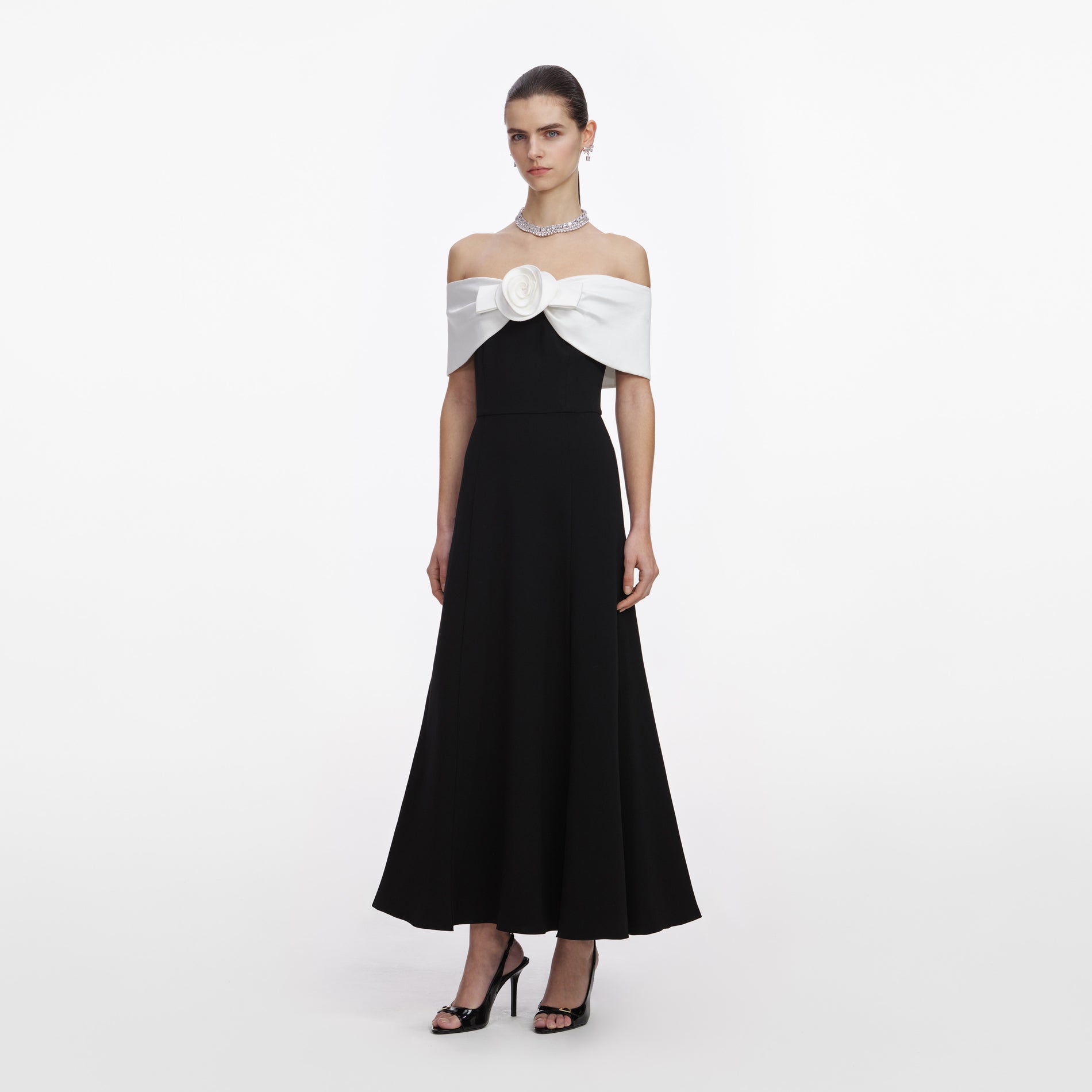 Side view of a woman wearing the Black Crepe Flower Midi Dress