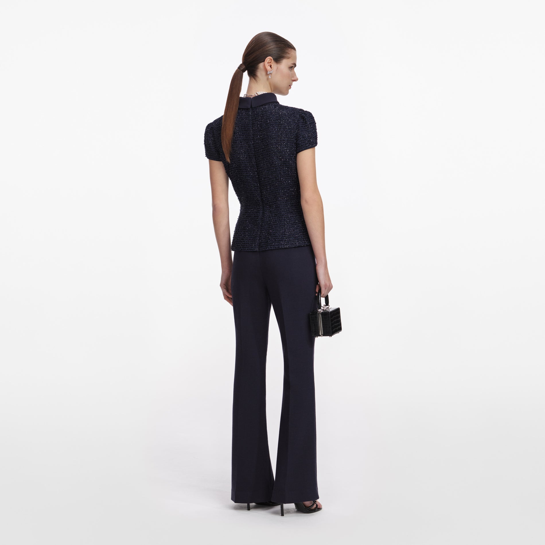 Back view of a woman wearing the Navy Metallic Boucle Jumpsuit