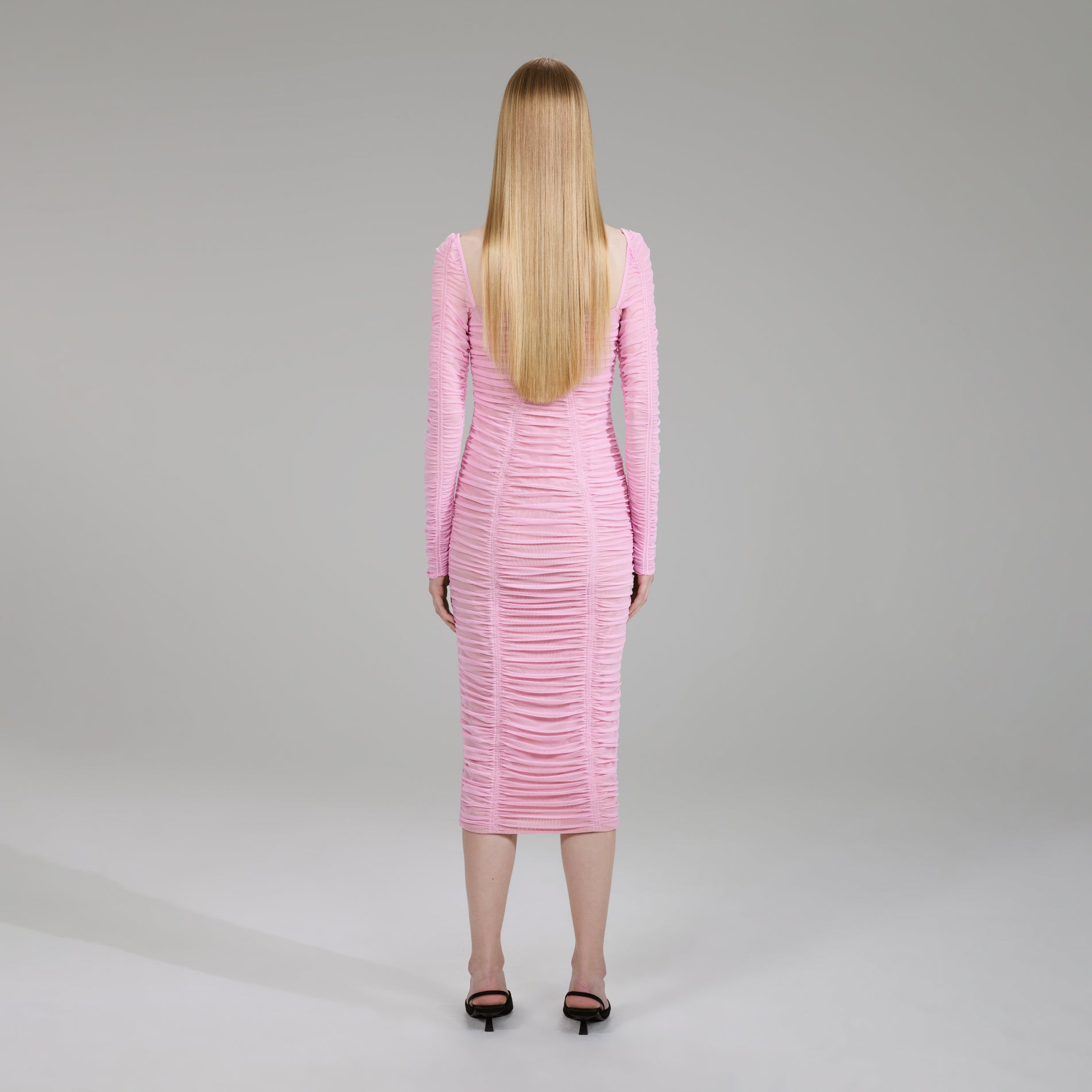 A woman wearing the Pink Power Mesh Long Sleeve Midi Dress