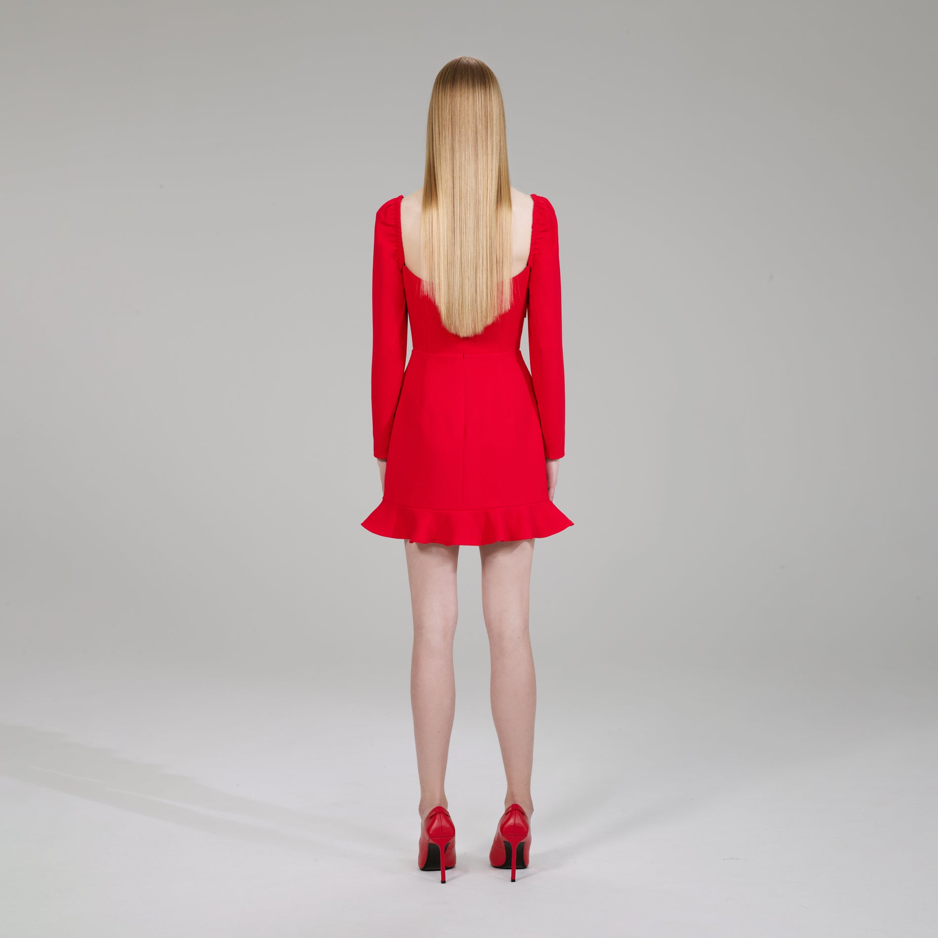 A woman wearing the Red Crepe Bow Mini Dress