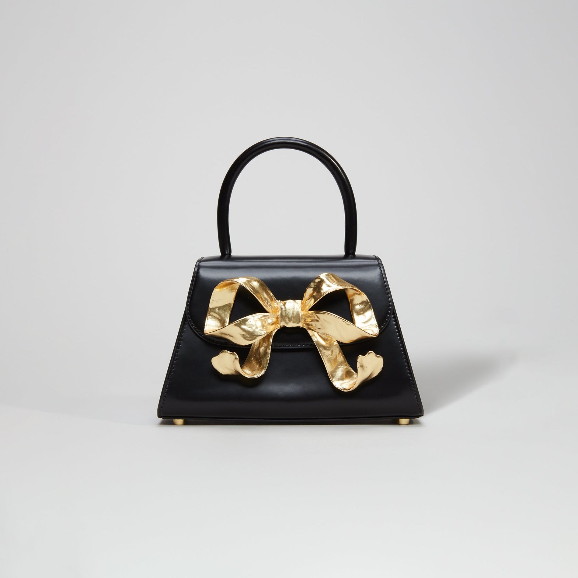 A woman wearing the The Bow Mini in Black with Gold Hardware
