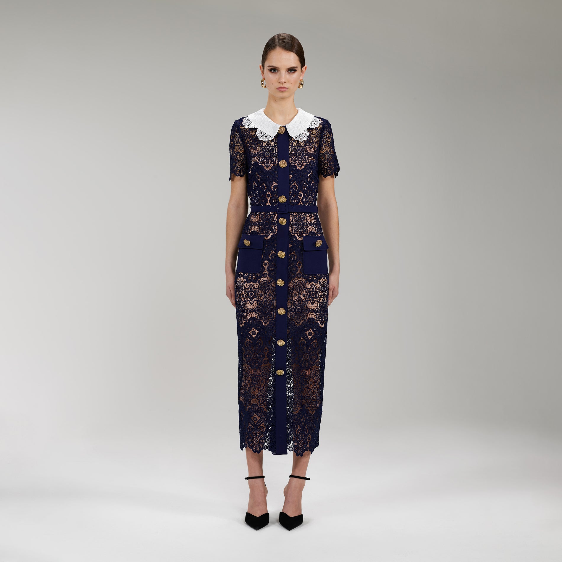 A woman wearing the Navy Floral Guipure Midi Dress