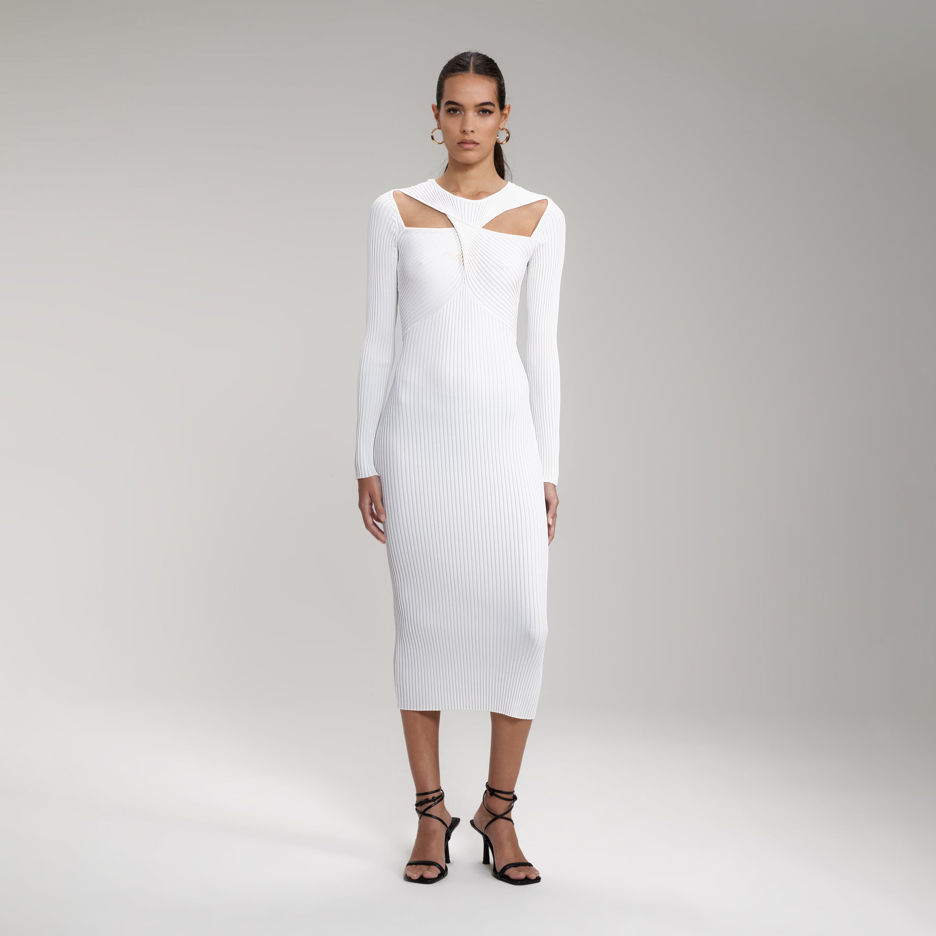 A woman wearing the White Ribbed Knit Cut Out Midi Dress