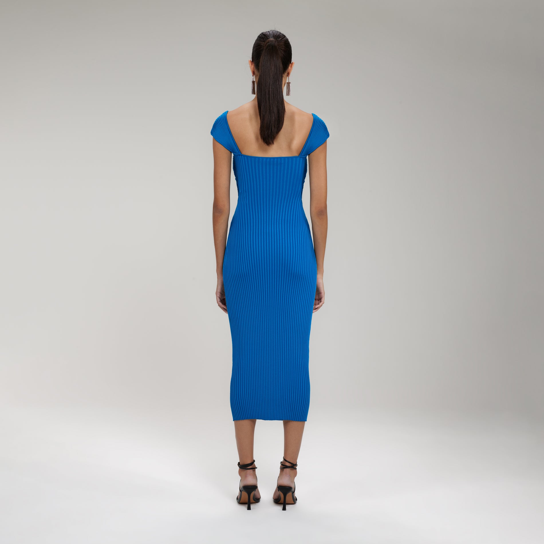 A woman wearing the Bright Blue Ribbed Knit Crossover Bust Midi Dress