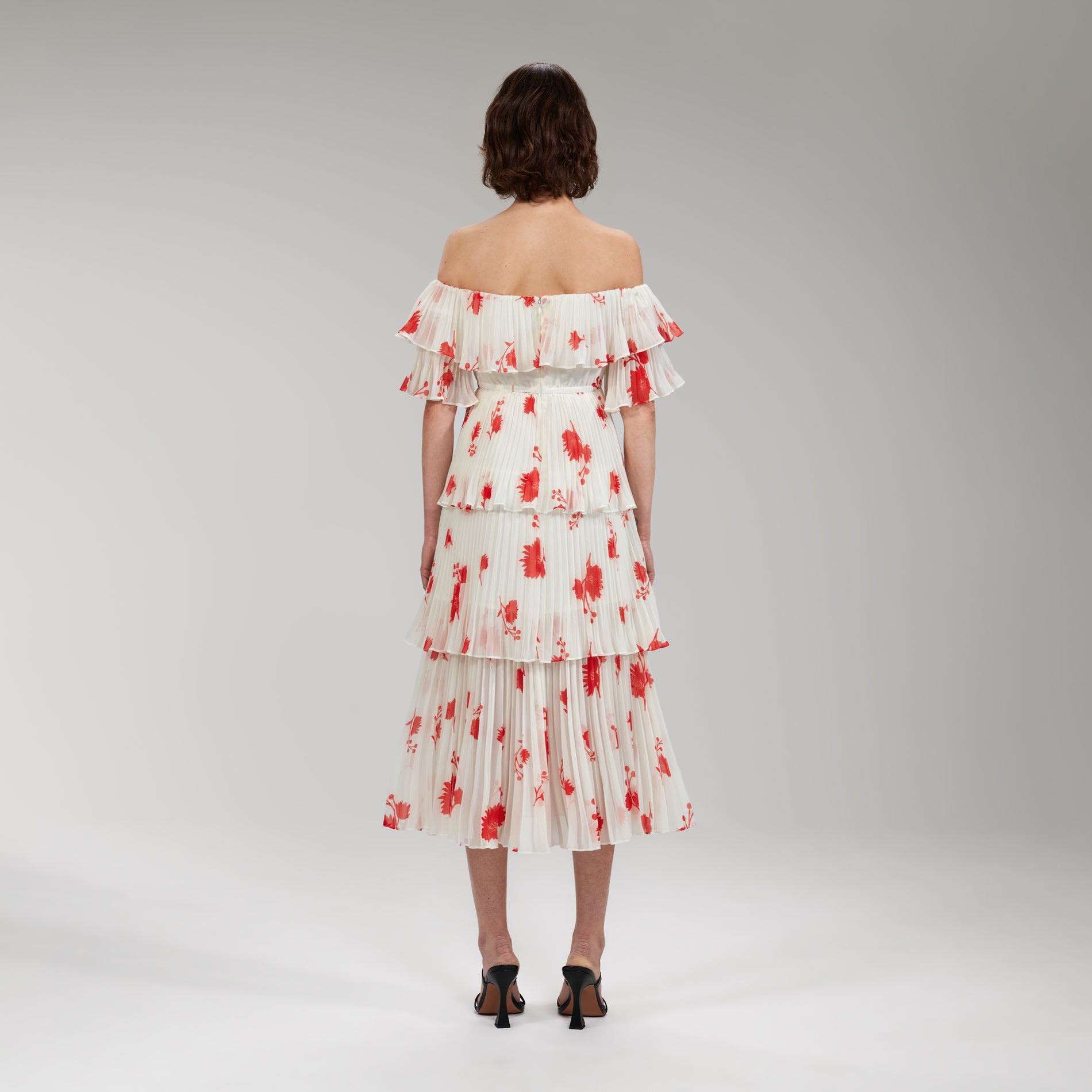 A woman wearing the Wild Daisy Print Pleated Strapless Midi Dress