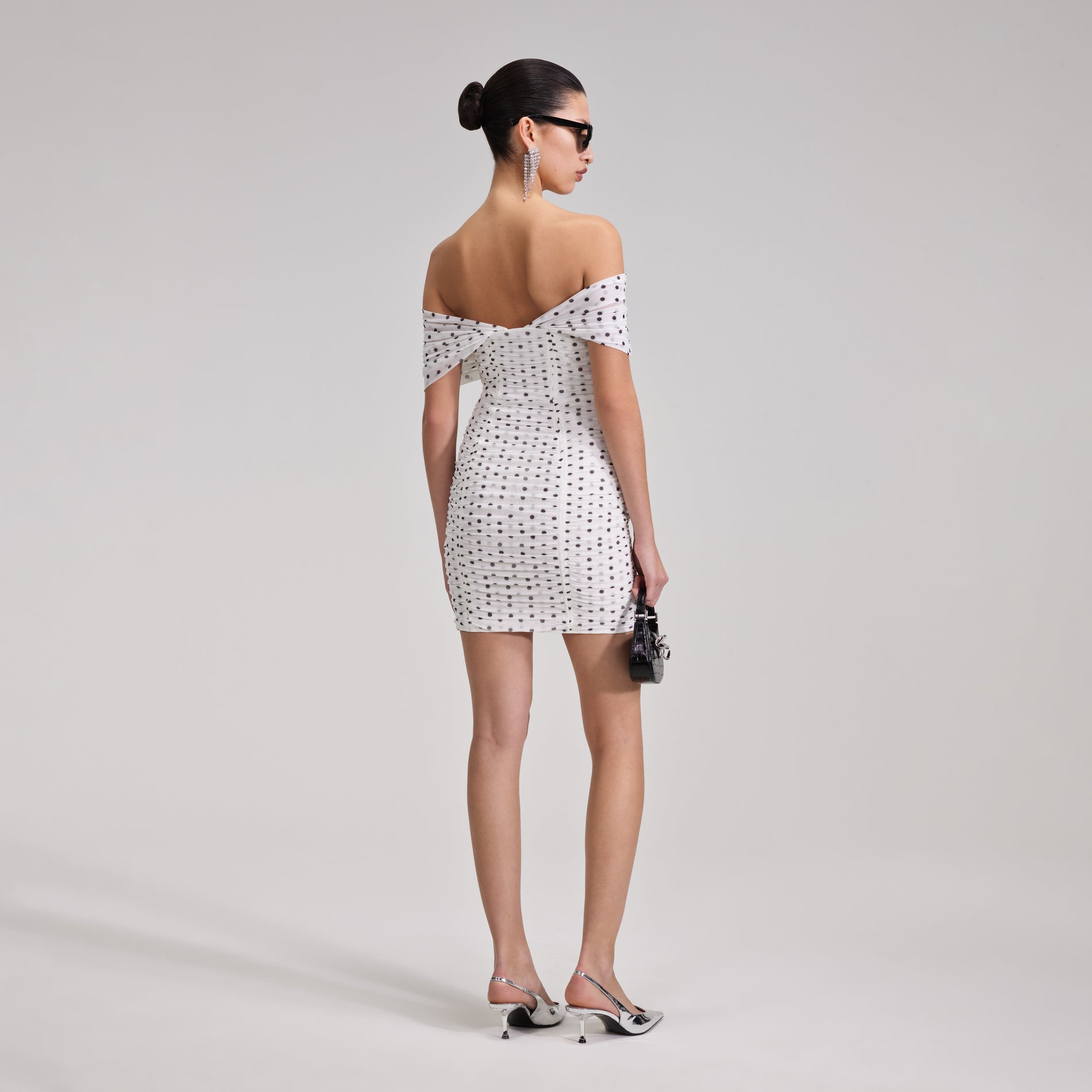 A woman wearing the Polka Dot Off Shoulder Mini Dress