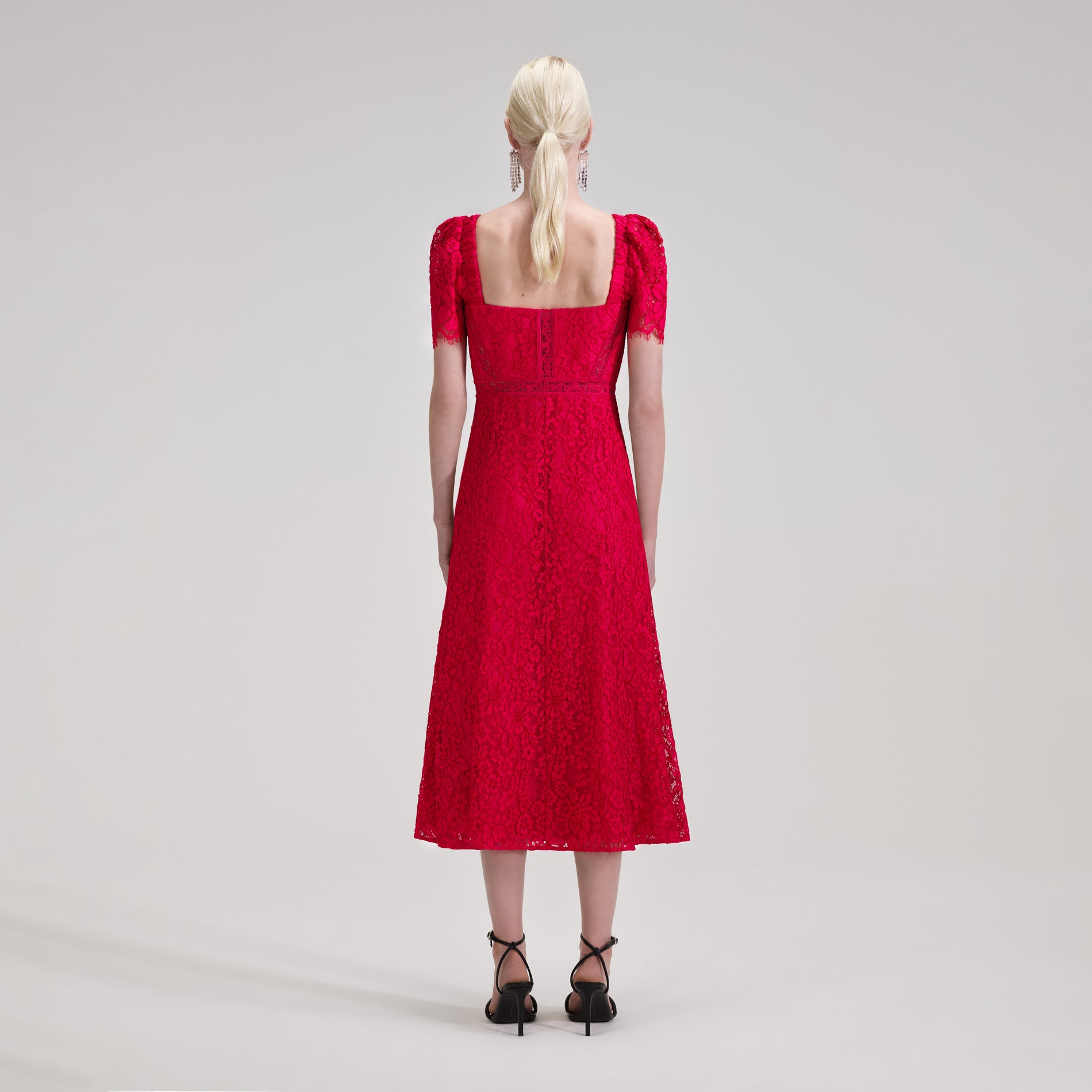 A woman wearing the Red Lace Midi Dress