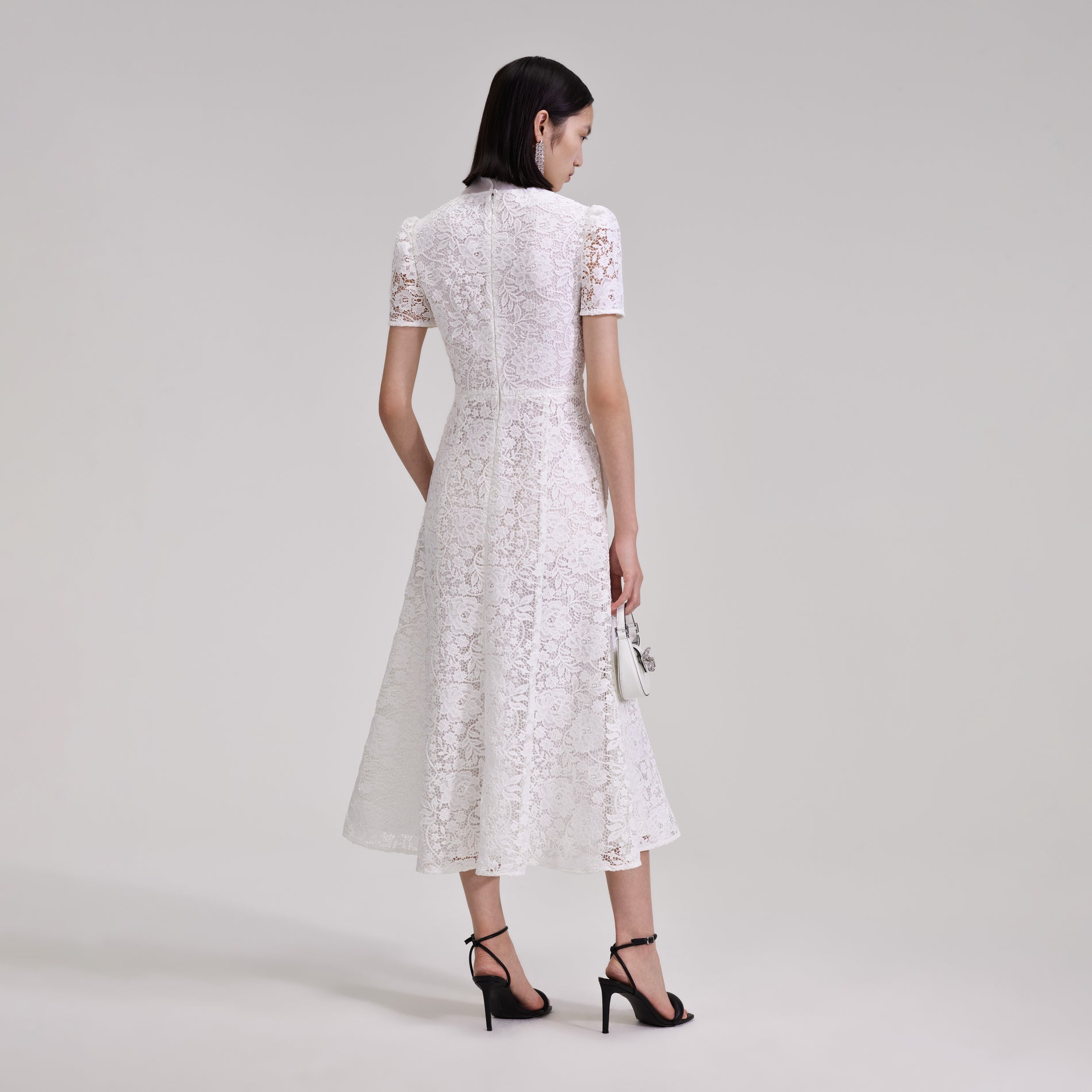 A woman wearing the White Cord Lace Crossover Midi Dress