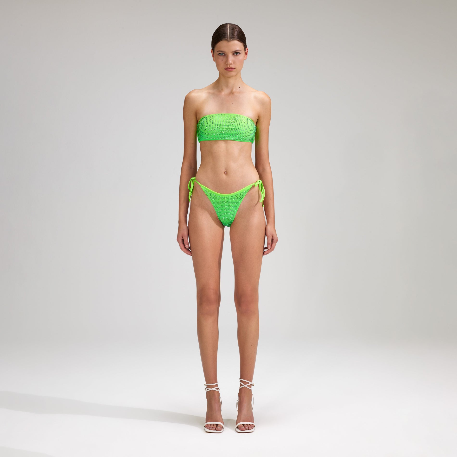A woman wearing the Green Rhinestone Tie Side Bikini Brief