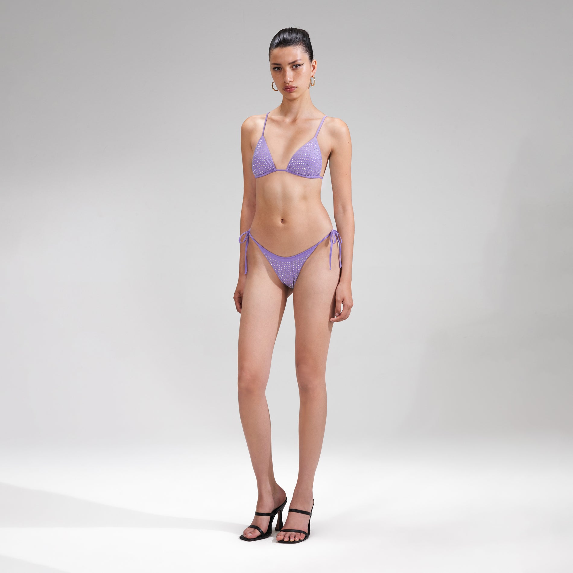 A woman wearing the Purple Rhinestone Bikini Brief