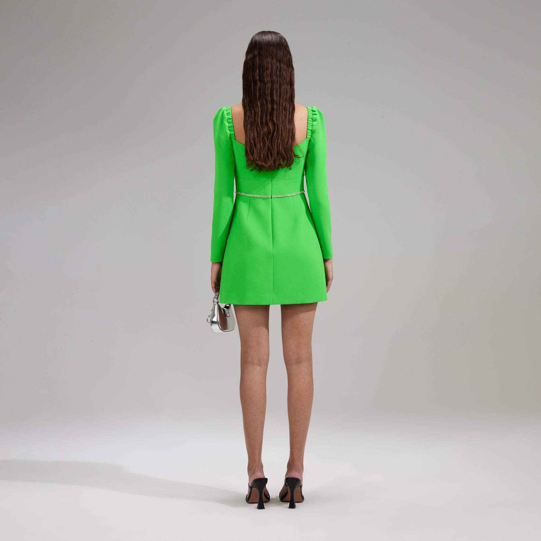 A woman wearing the Green Crepe Rhinestone Detail Mini Dress