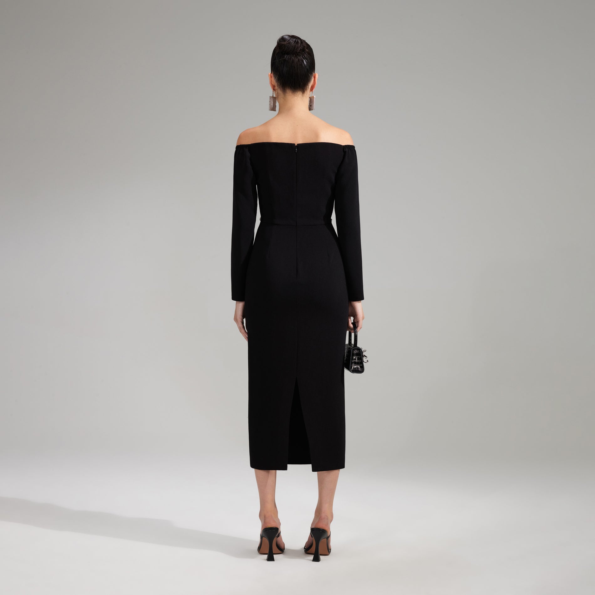 A woman wearing the Black Off Shoulder Heavy Crepe Midi Dress