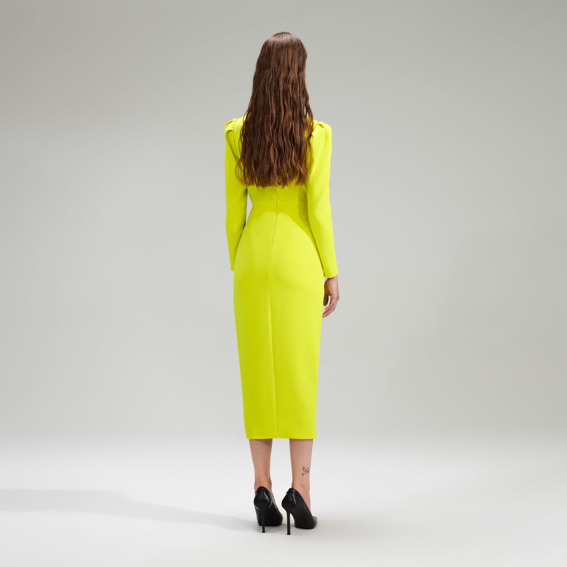 A woman wearing the Lime Crepe Ruched Midi Dress