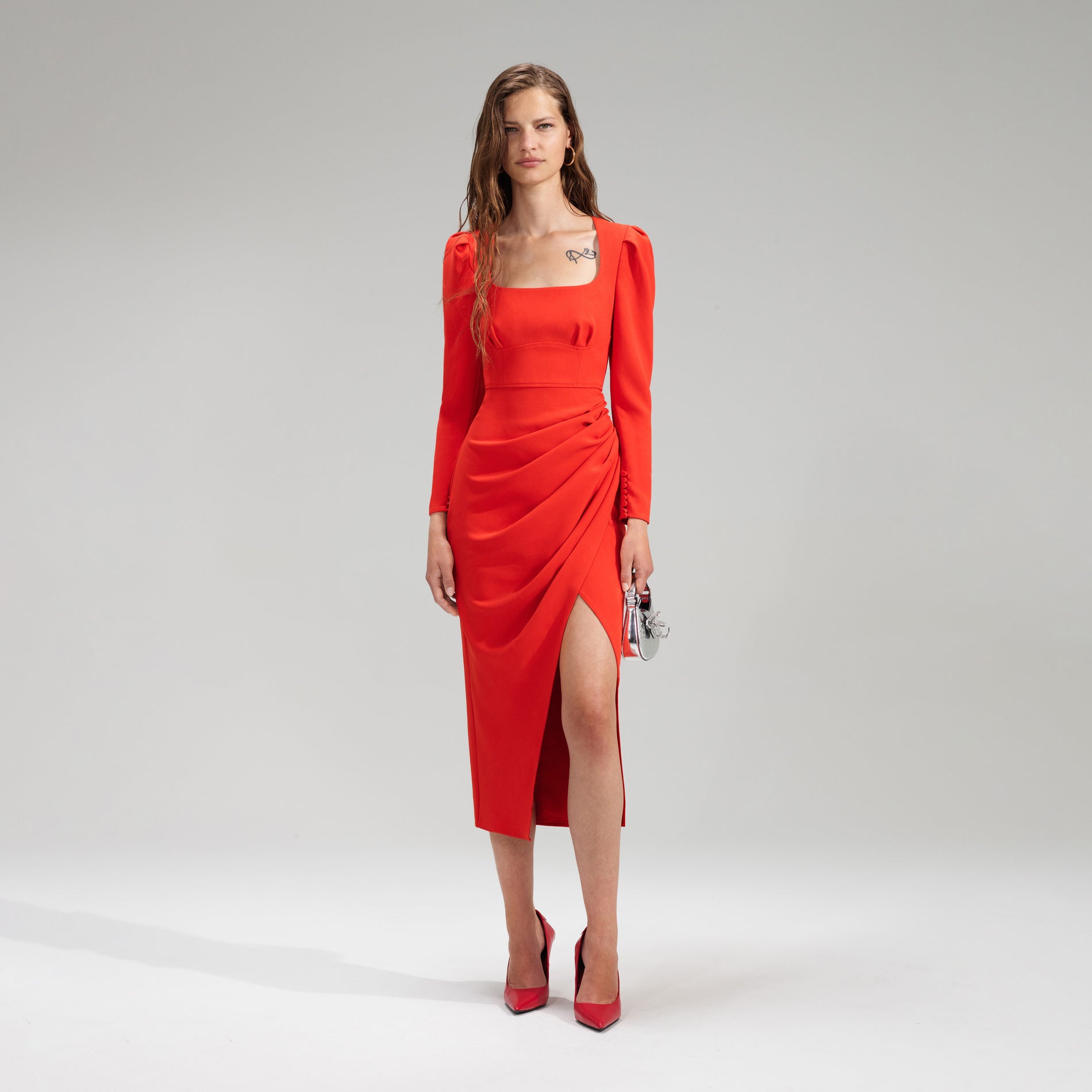 A woman wearing the Red Crepe Ruched Midi Dress