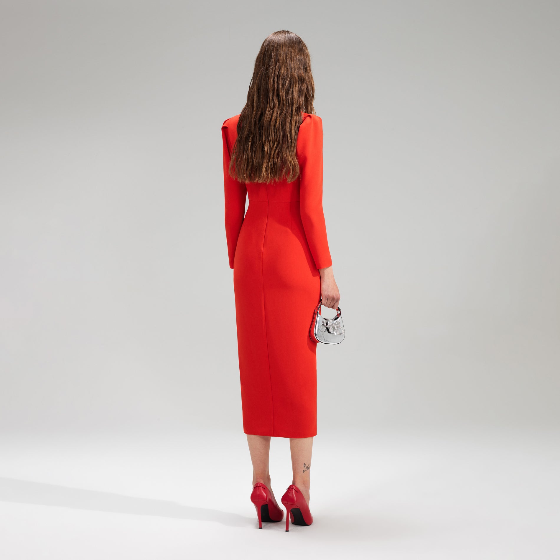 A woman wearing the Red Crepe Ruched Midi Dress
