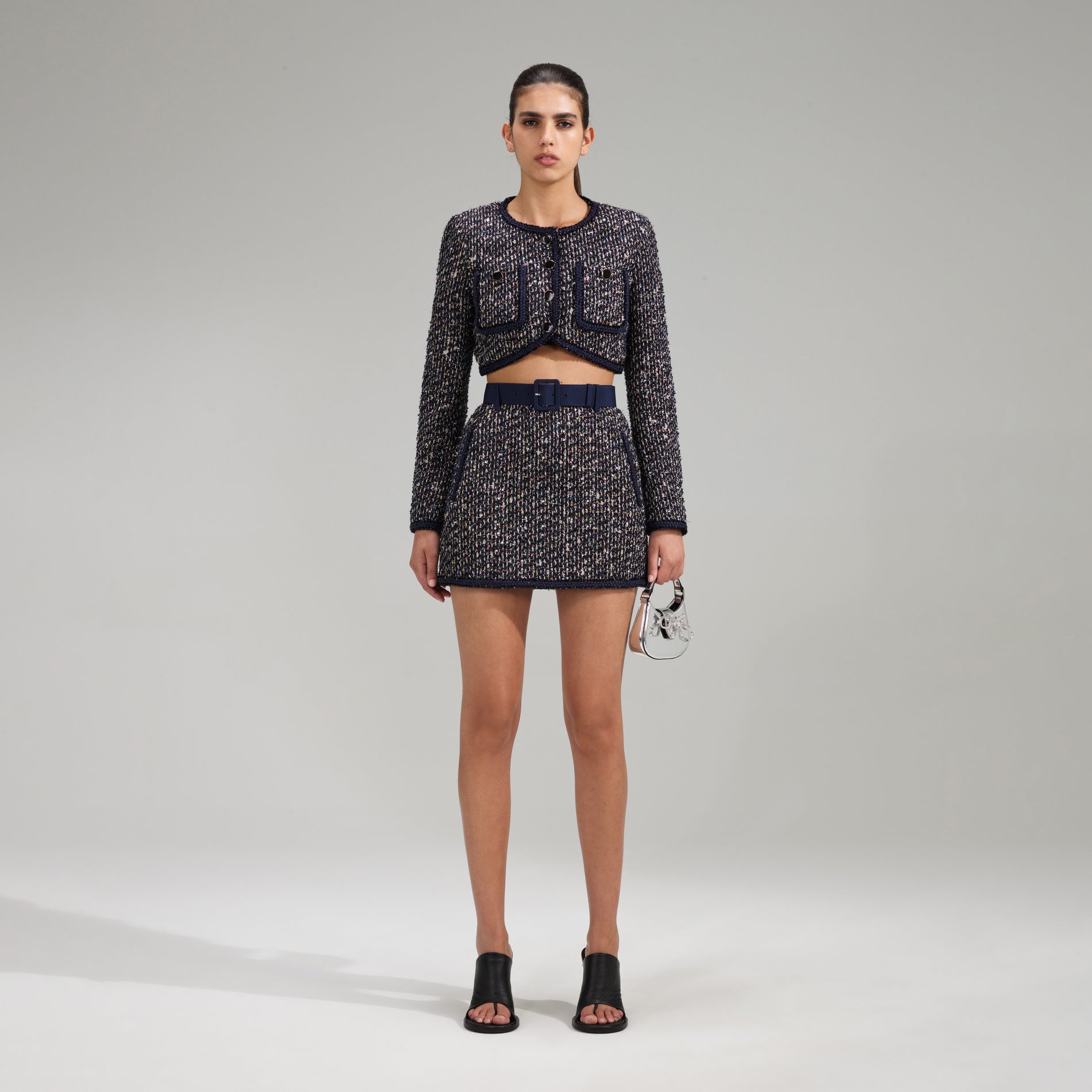 A woman wearing the Boucle Mini Skirt With Braid Detail