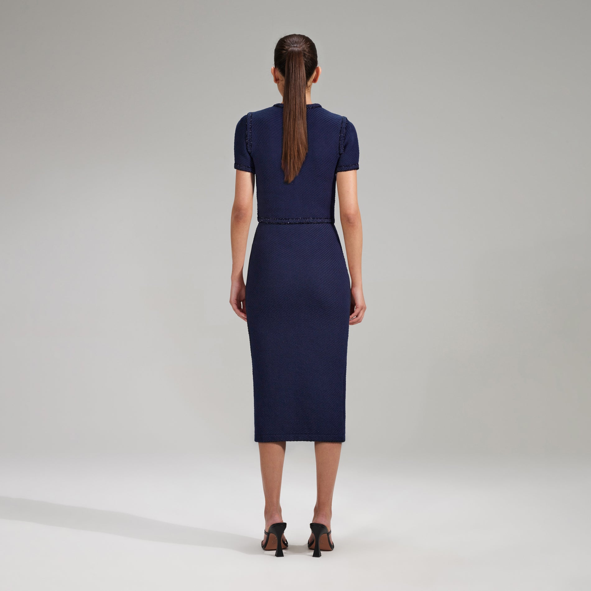 A woman wearing the Navy Knit Midi Skirt