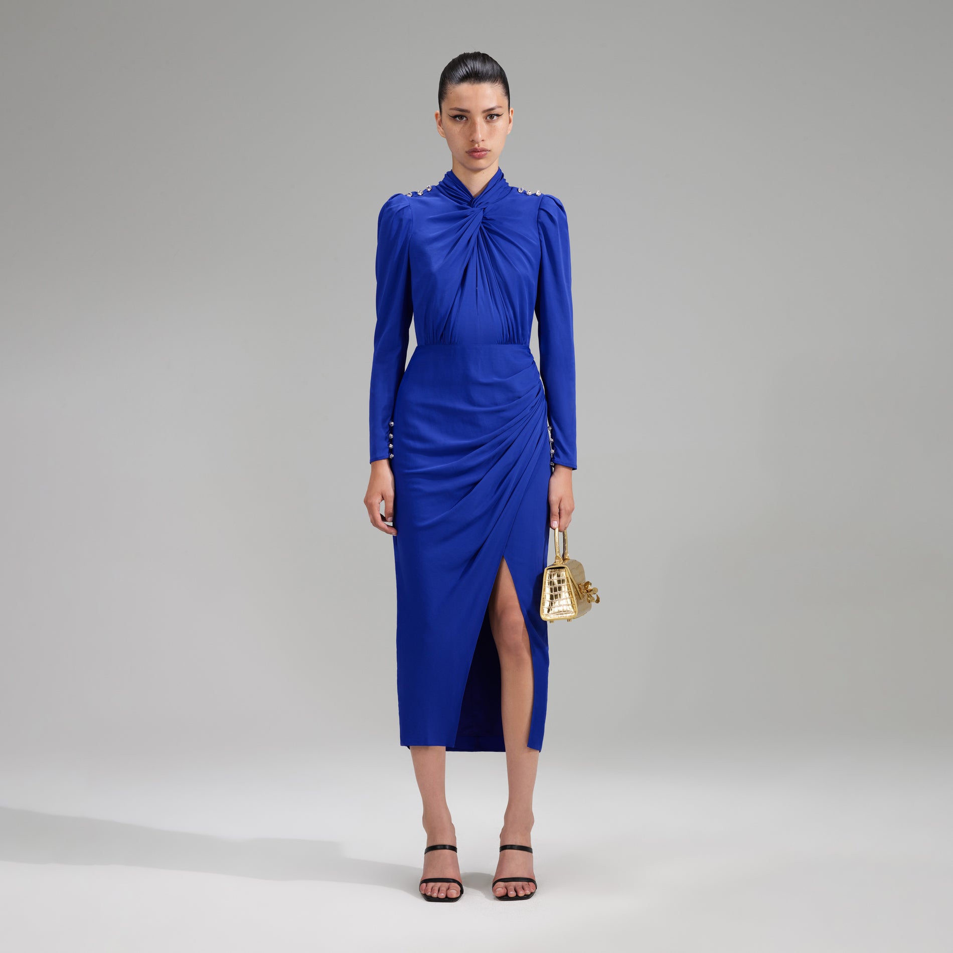 A woman wearing the Blue Stretch Crepe Twisted Collar Midi Dress