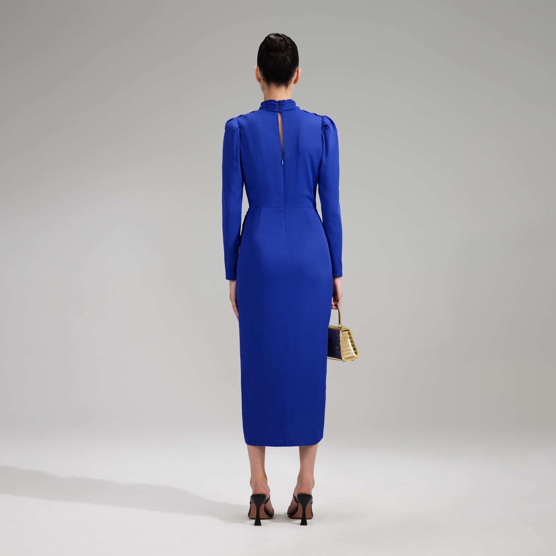 A woman wearing the Blue Stretch Crepe Twisted Collar Midi Dress