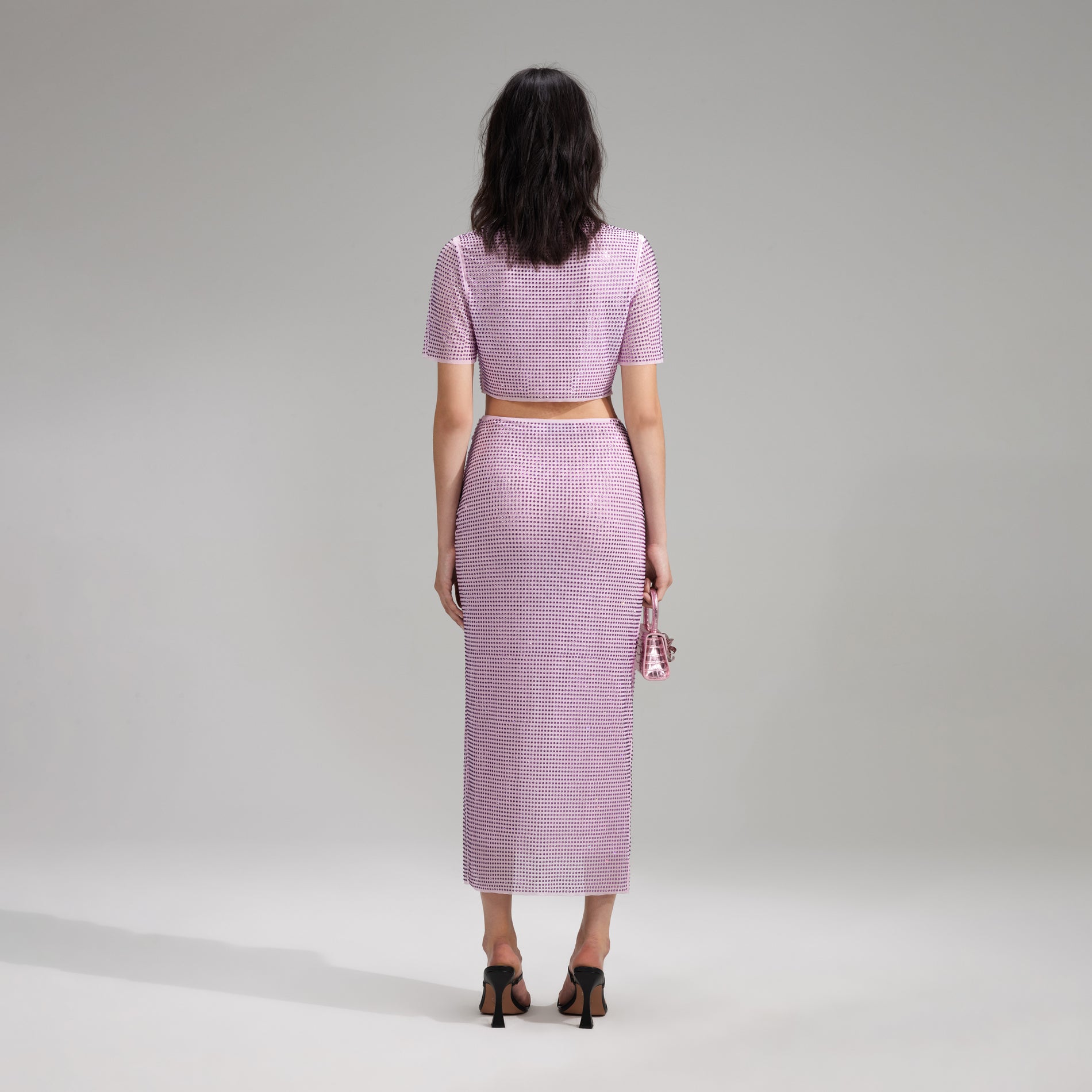 A woman wearing the Lilac Rhinestone Wrap Midi Skirt