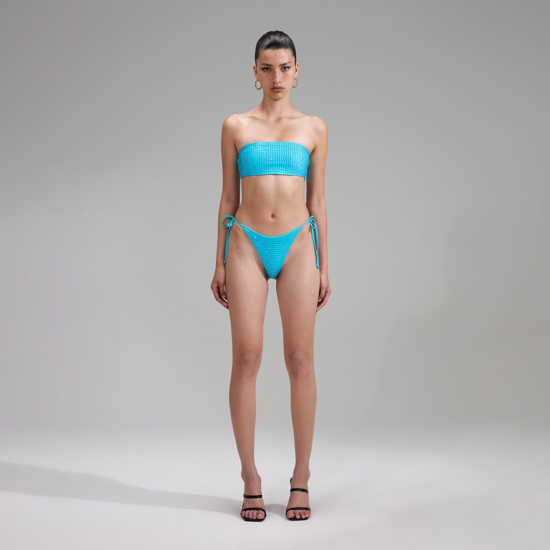 A woman wearing the Blue Rhinestone Brazilian Bikini Briefs
