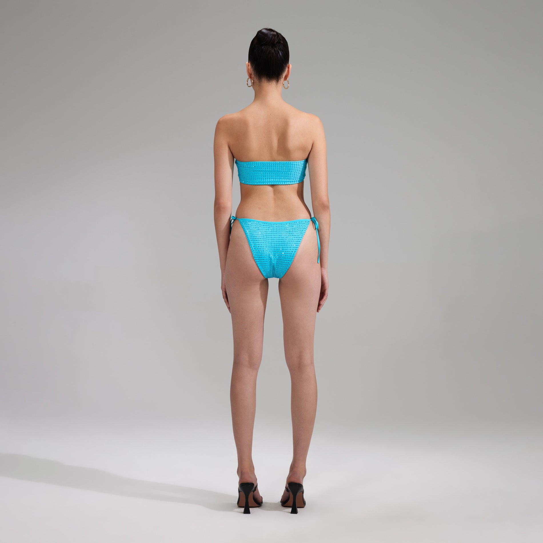 A woman wearing the Blue Rhinestone Brazilian Bikini Briefs