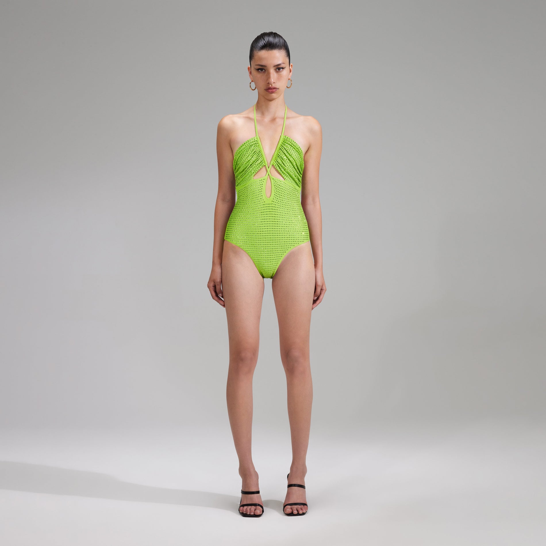 A woman wearing the Green Rhinestone Strappy Swimsuit
