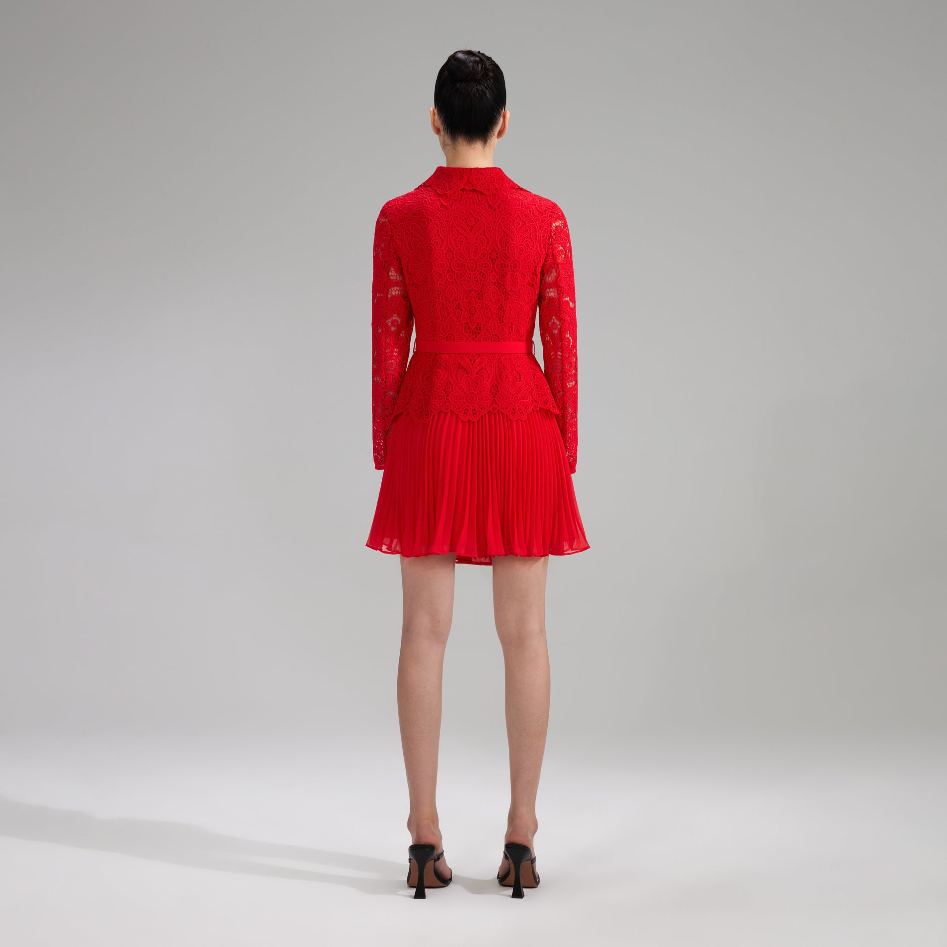 A woman wearing the Red Buttoned Guipure Lace Mini Dress