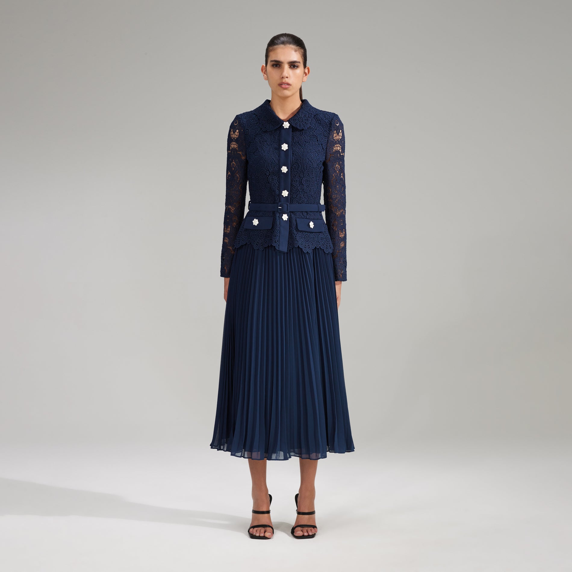A woman wearing the Navy Guipure Lace Midi Dress