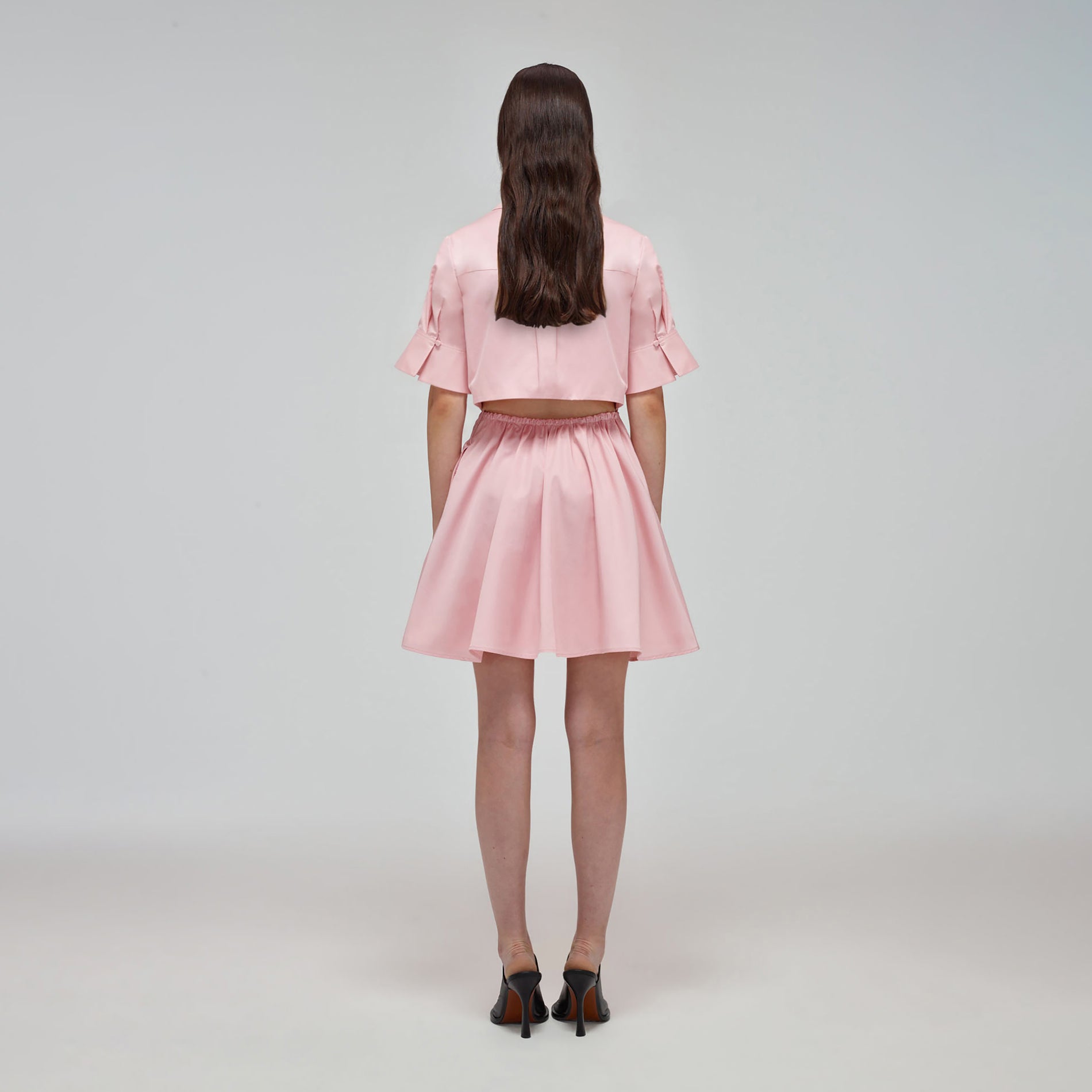 A woman wearing the Pink Organic Cotton Cut Out Mini Dress
