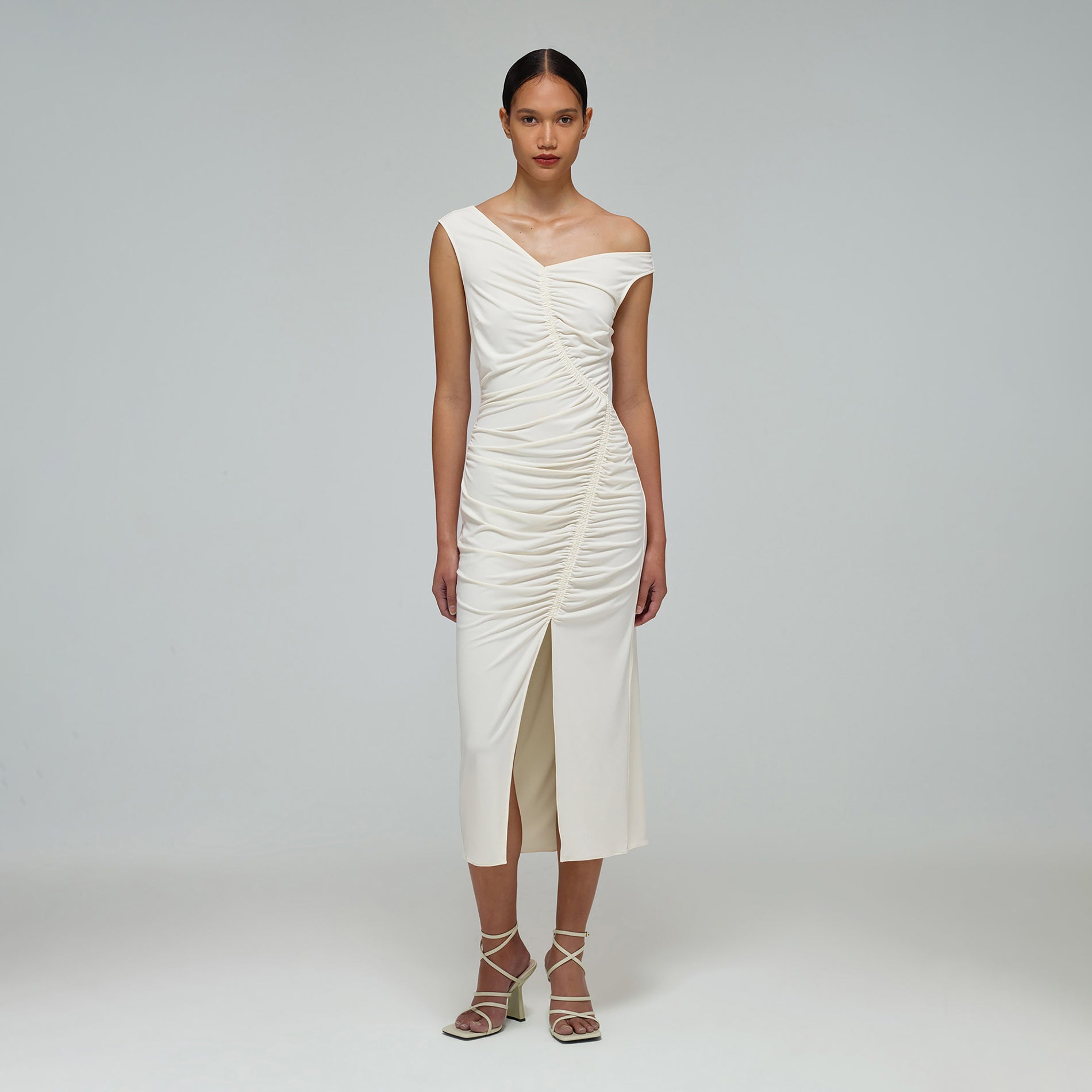 A woman wearing the Ivory Jersey Gathered Asymmetric Midi Dress