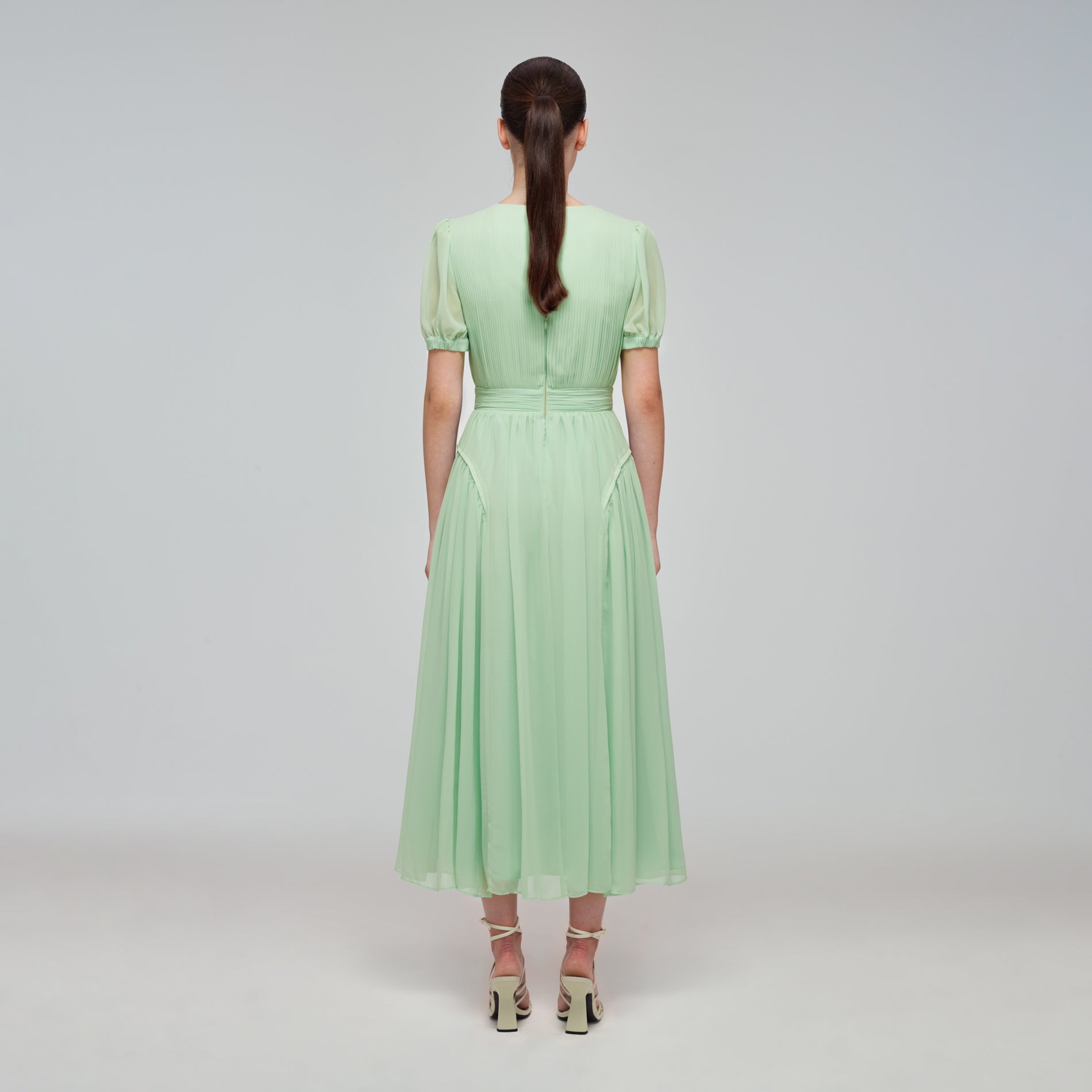 A woman wearing the Spearmint Chiffon Midi Dress