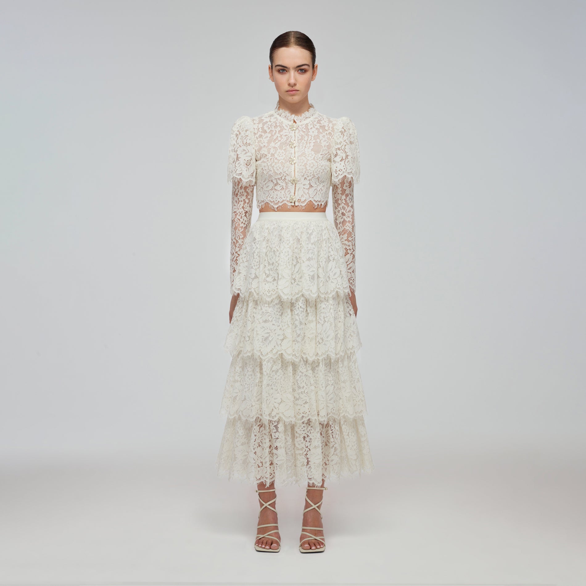A woman wearing the Ivory Corded Lace Tiered Midi Skirt