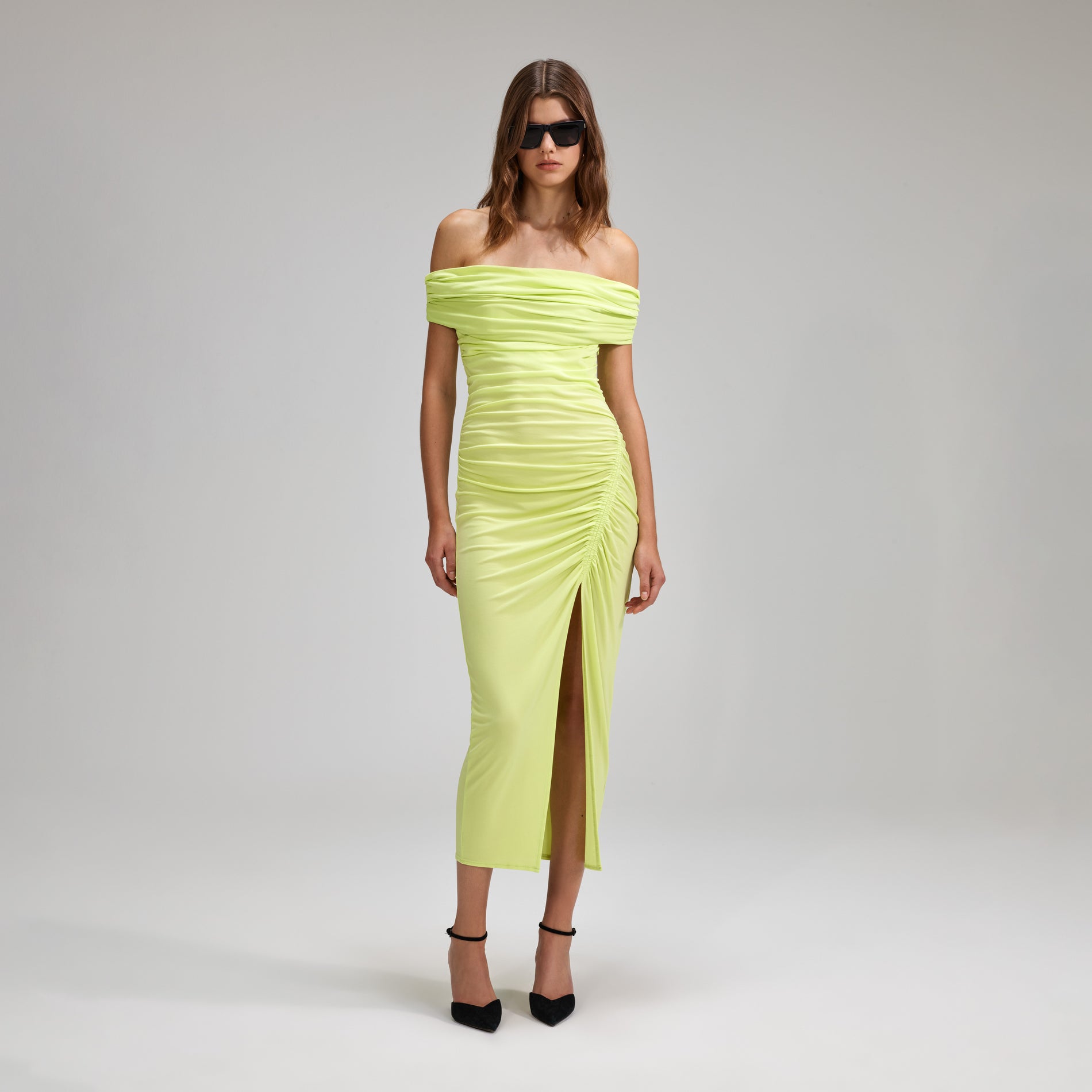 A woman wearing the Lime Jersey Off-Shoulder Midi Dress