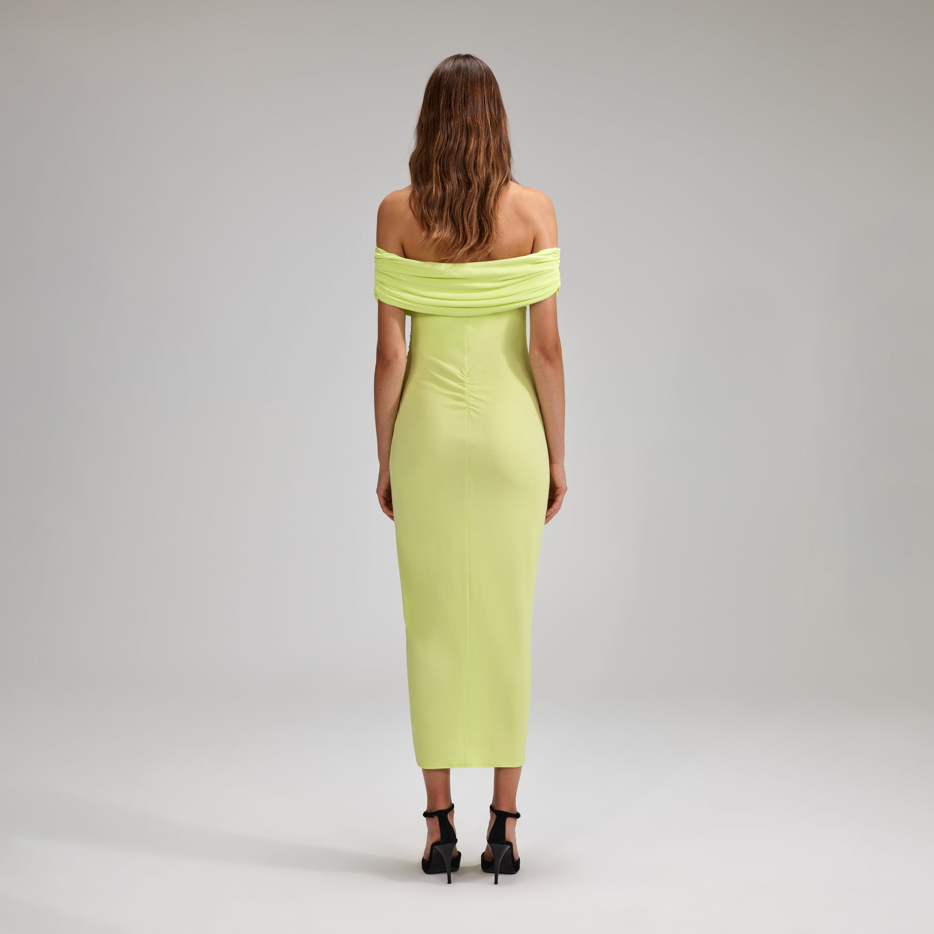 A woman wearing the Lime Jersey Off-Shoulder Midi Dress