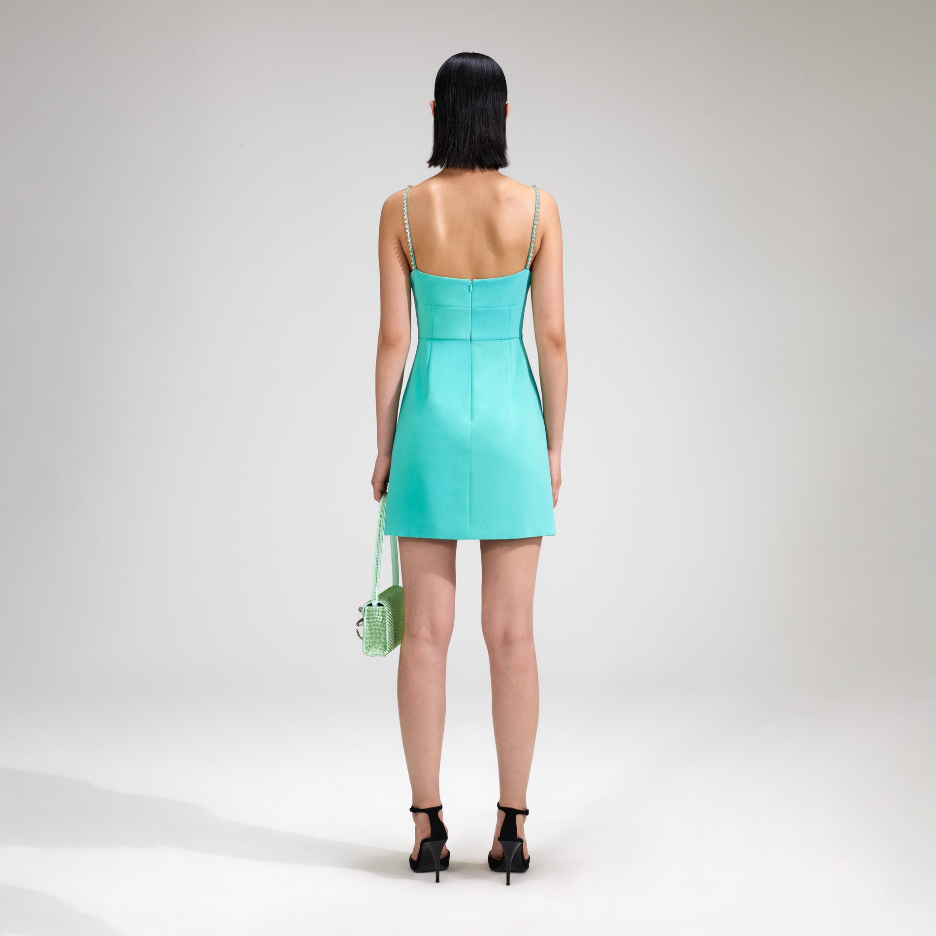 A woman wearing the Aqua Crepe Mini Dress