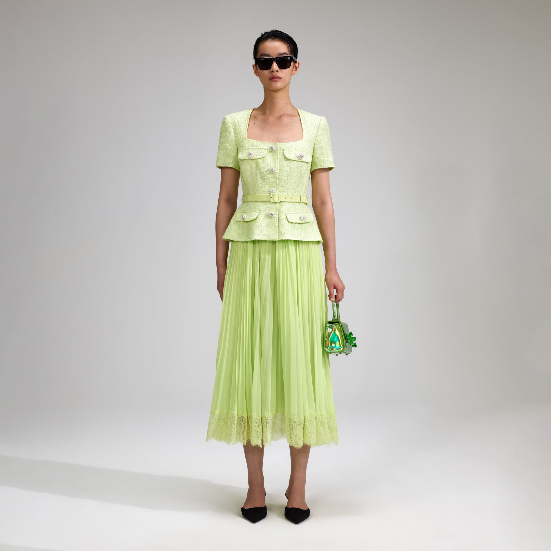 A woman wearing the Lime Boucle Chiffon Midi Dress
