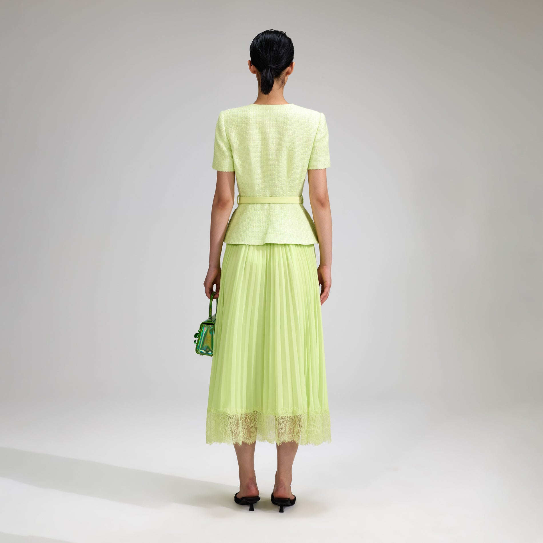 A woman wearing the Lime Boucle Chiffon Midi Dress