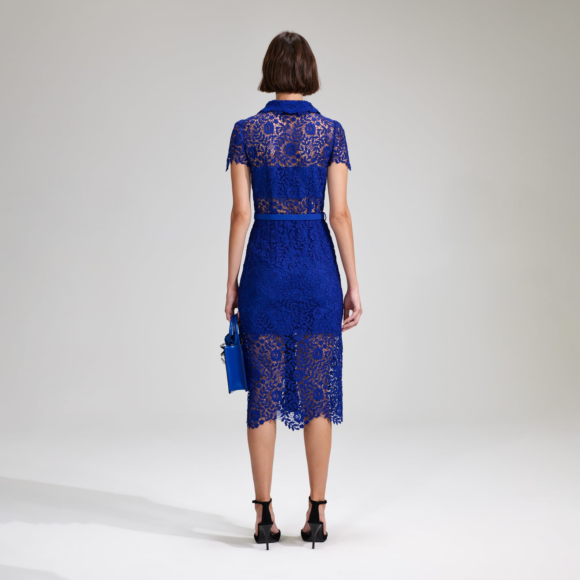 A woman wearing the Cobalt Rose Lace Button Midi Dress
