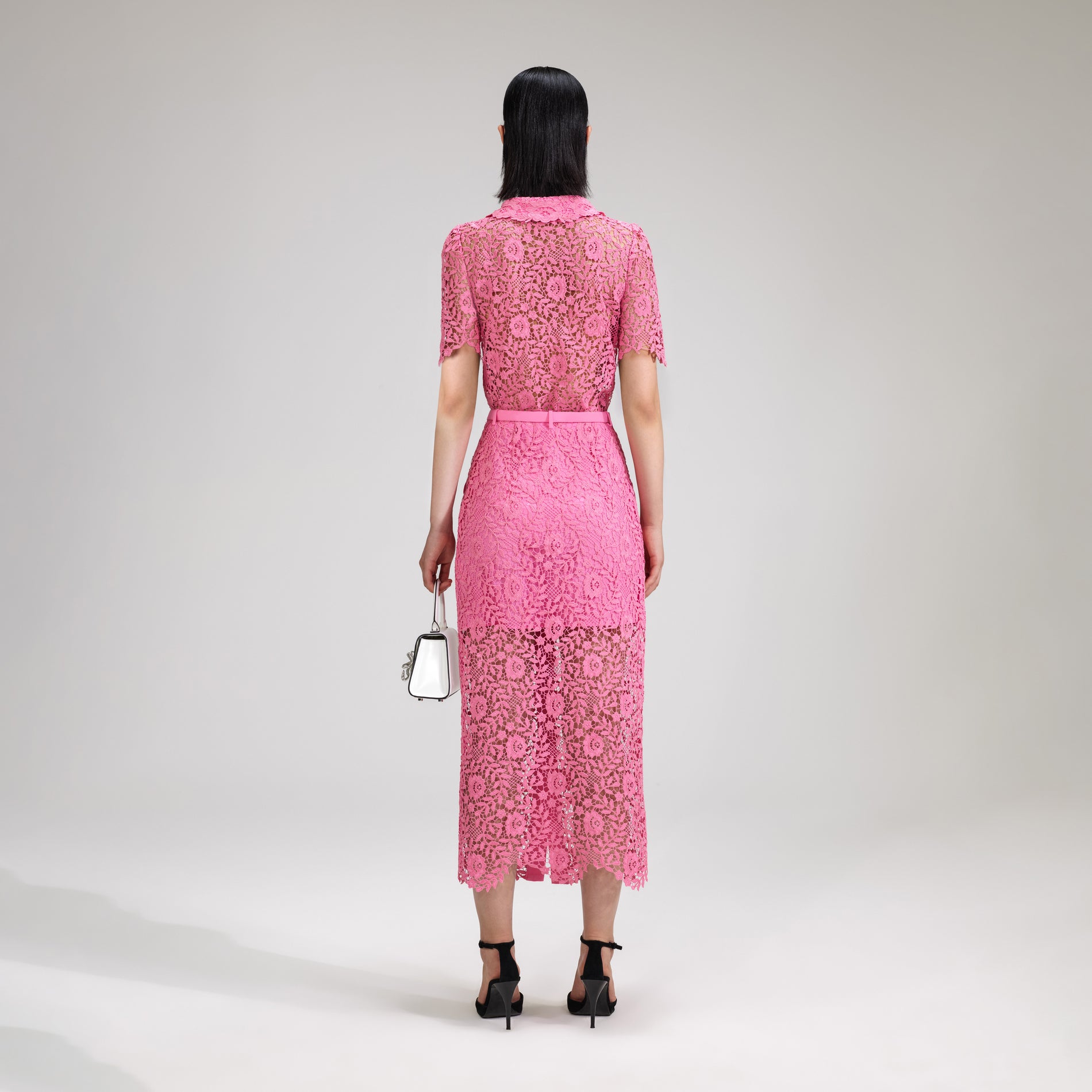 A woman wearing the Pink Rose Lace Midi Skirt