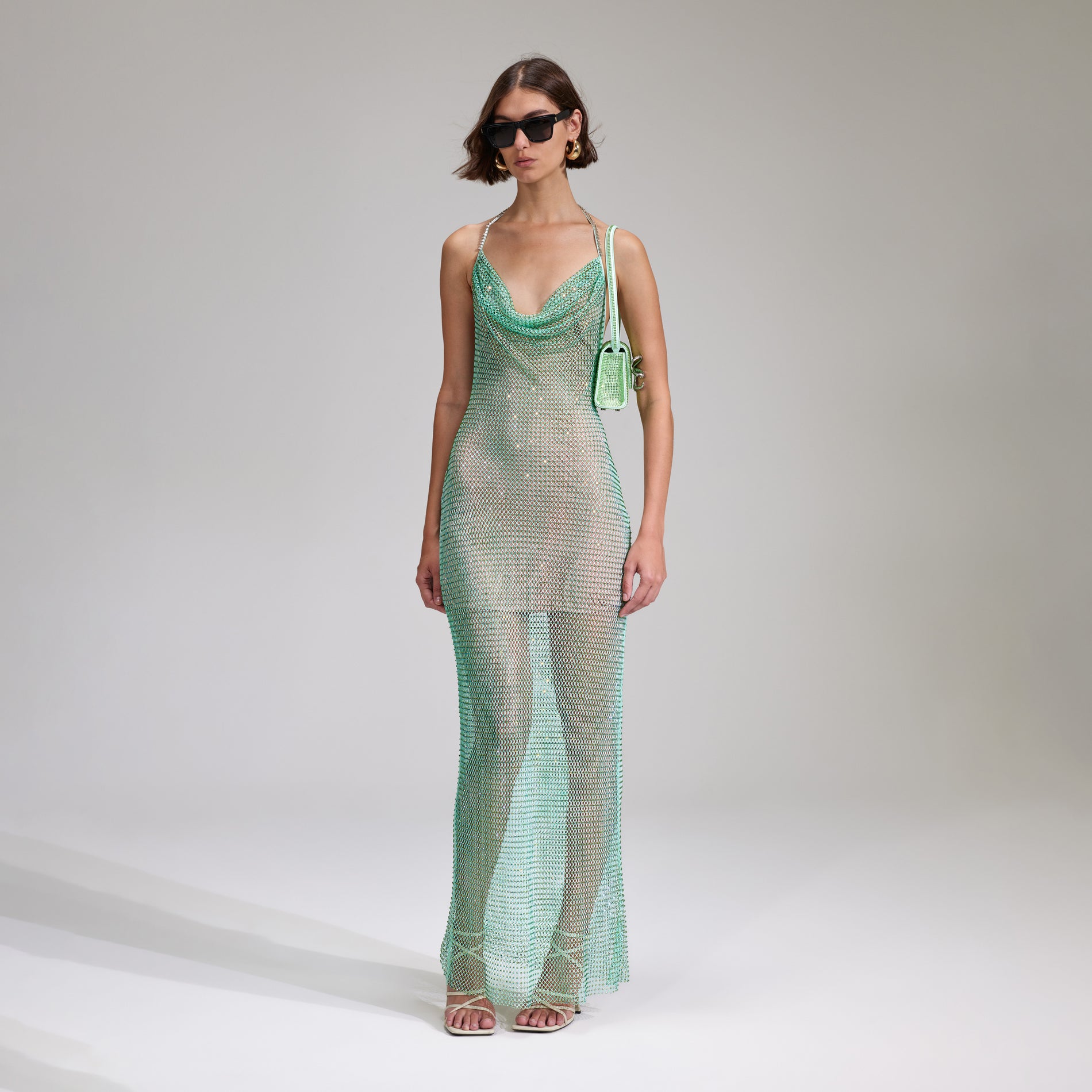 A woman wearing the Mint Rhinestone Fishnet Cowl Maxi Dress