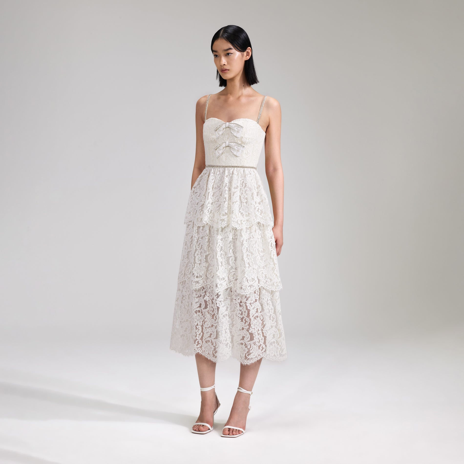 A woman wearing the Cream Cord Lace Tiered Midi Dress