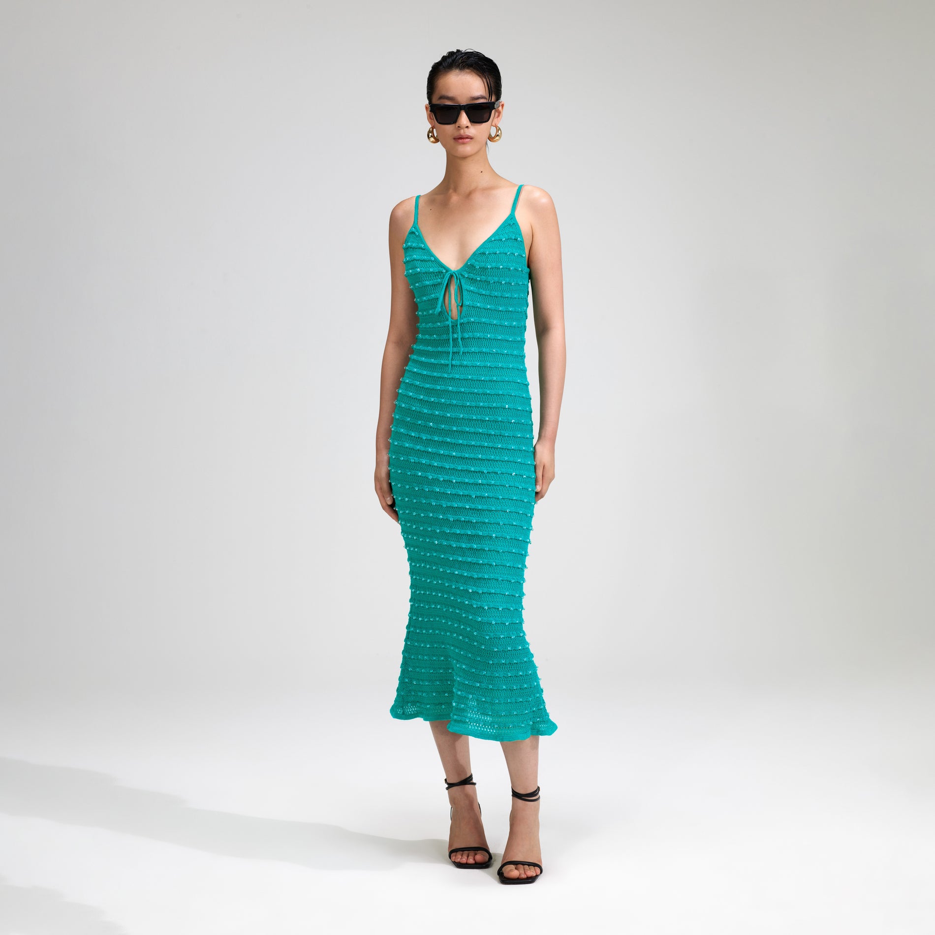 A woman wearing the Green Beaded Strappy Knit Midi Dress