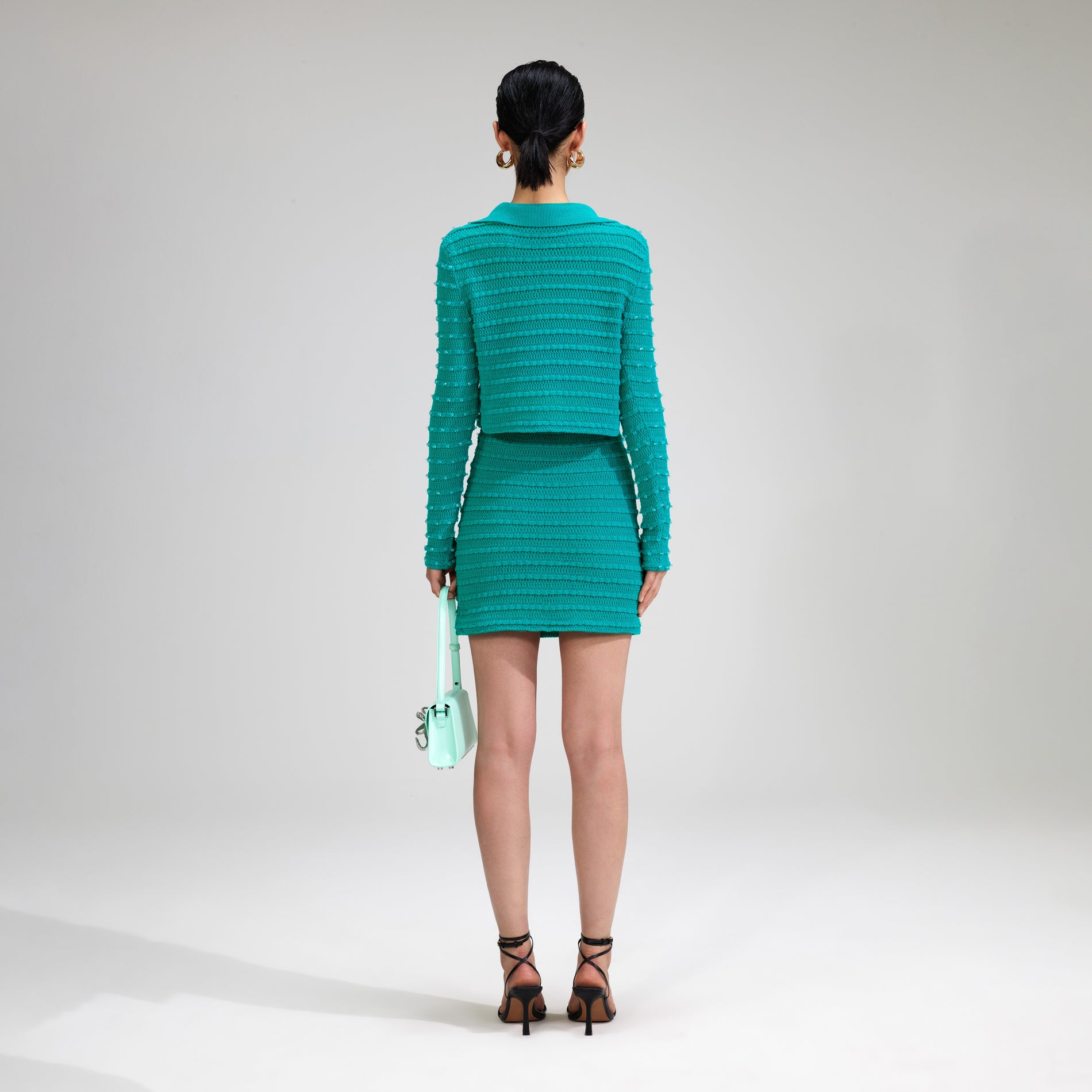 A woman wearing the Green Beaded Knit Mini Skirt