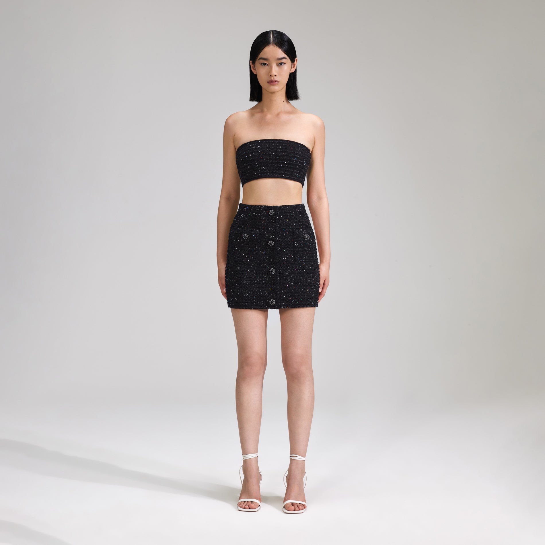 A woman wearing the Black Sequin Knit Bandeau Top